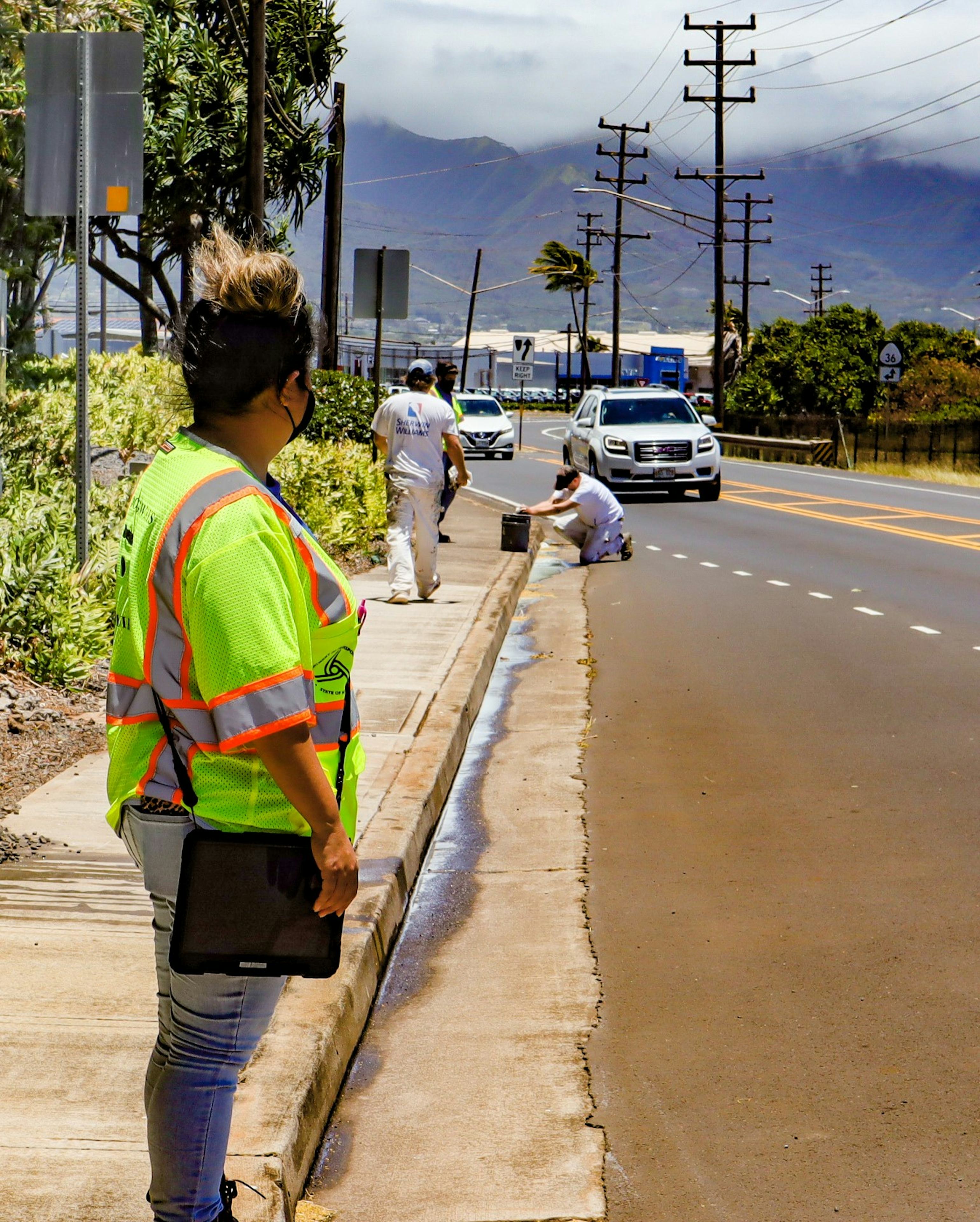 person on sidewalk looking at stormwater runoff