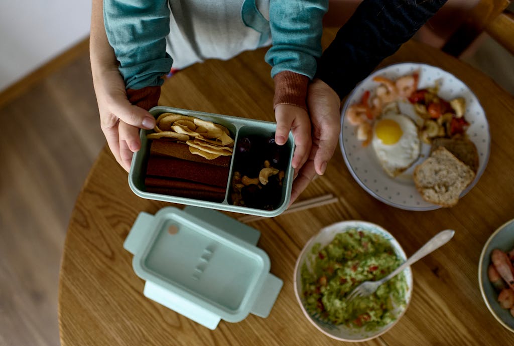 Mama z dzieckiem, pakująca lunchbox do pracy i szkoły