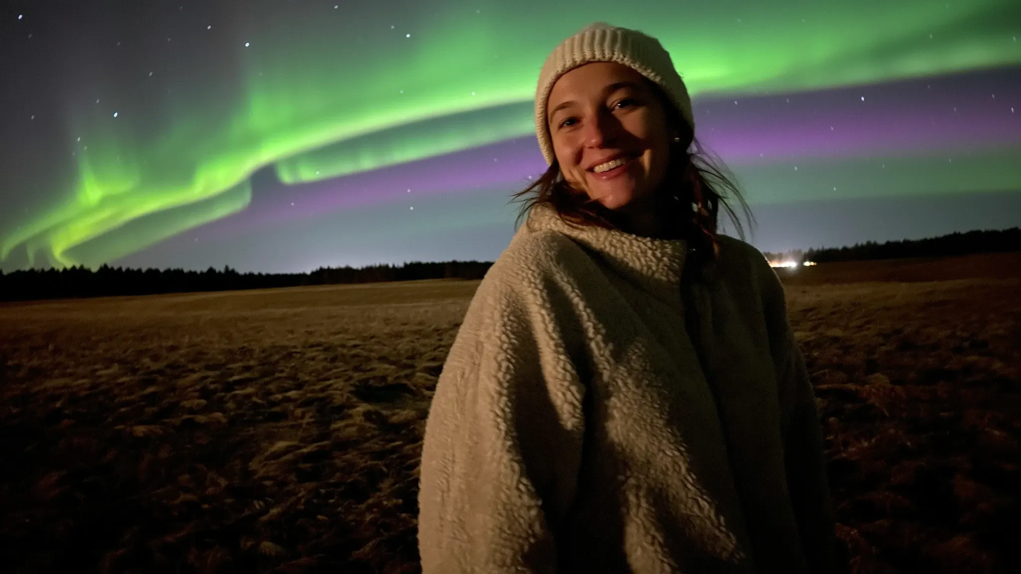 A women standing in front of the Northern Lights