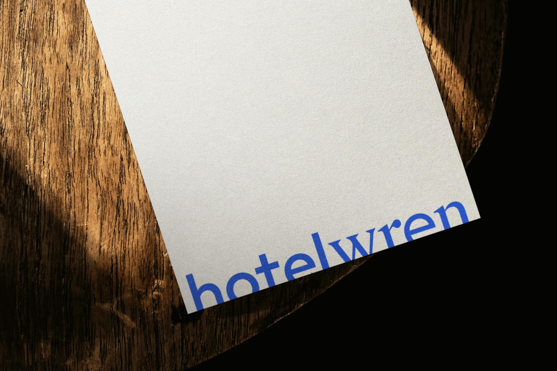 paper with HotelWren written on it laying wooden chair