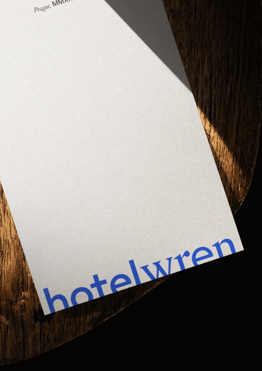 paper with HotelWren written on it laying wooden chair