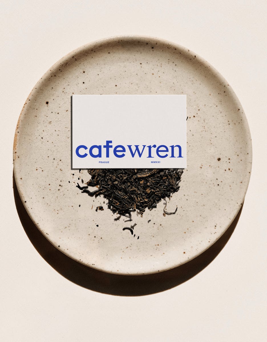 business card on plate of black tea