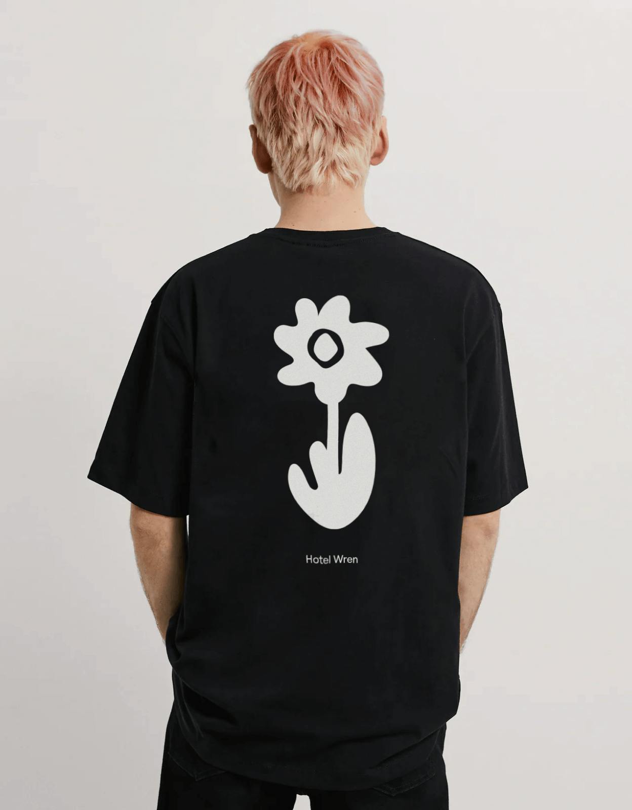 man wearing black t-shirt with flower illustration on back