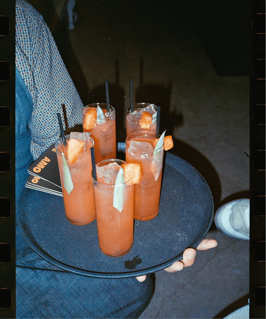 server holding tray of cocktails