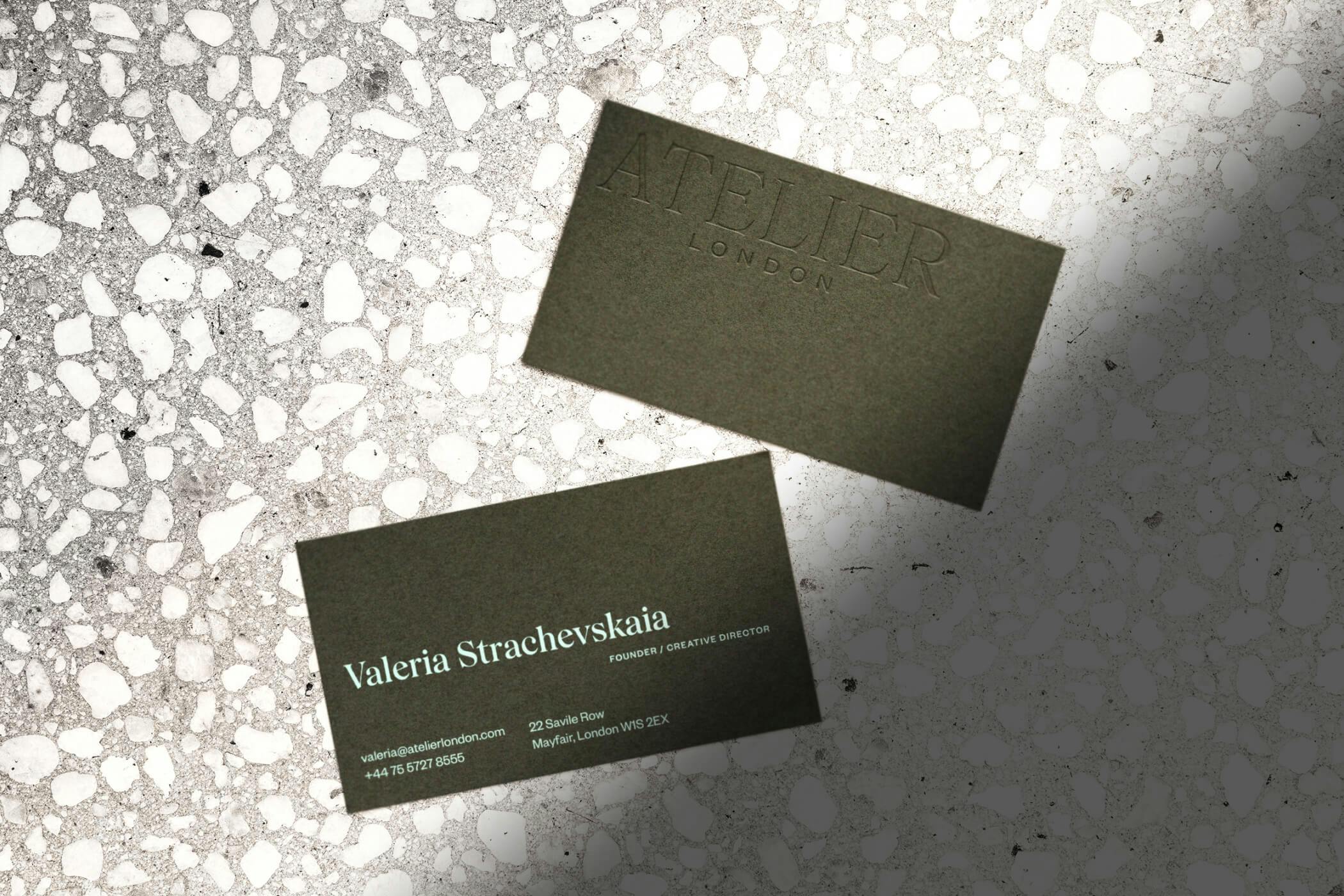 two business cards on stone floor