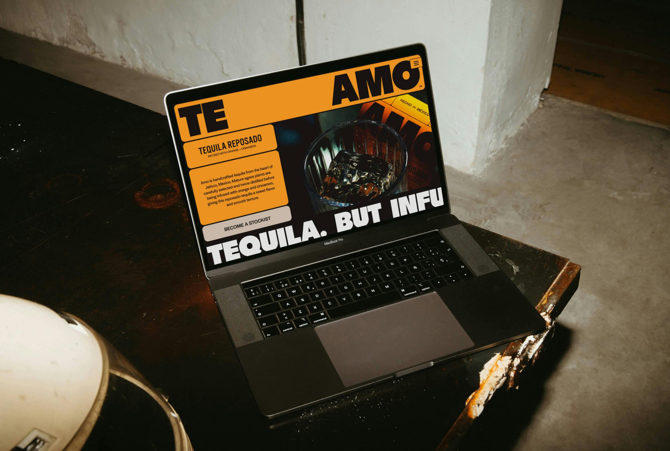 A laptop showing a webpage for TE AMO tequila on top of a table