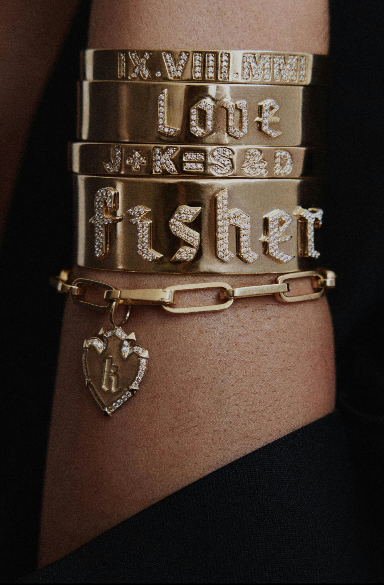 A close-up shot of a woman's wrist with many gold bracelets