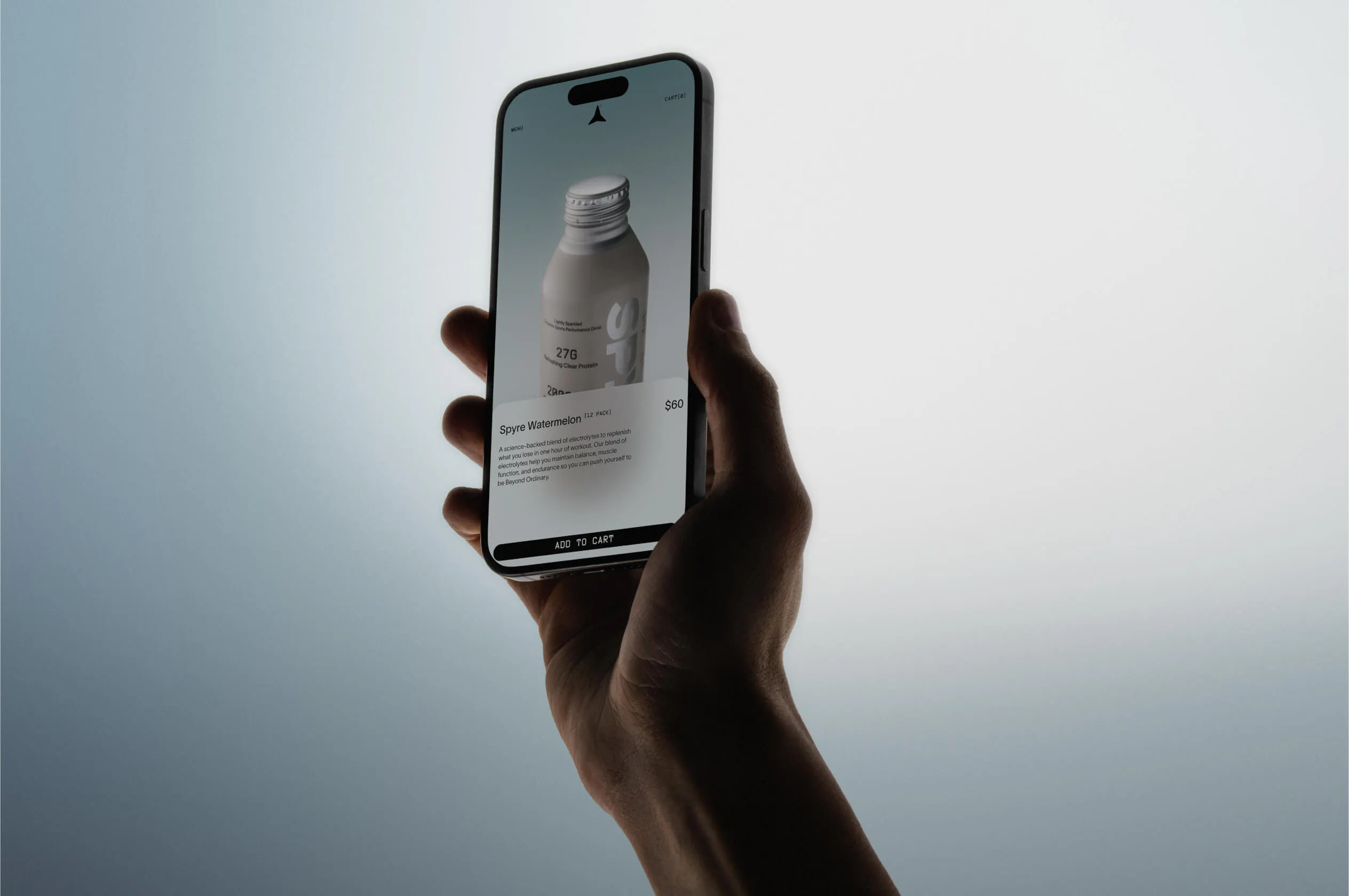 Hand holding a smartphone displaying the SPYRE mobile product page for Spyre Watermelon 12-pack priced at $60, against a soft gradient background