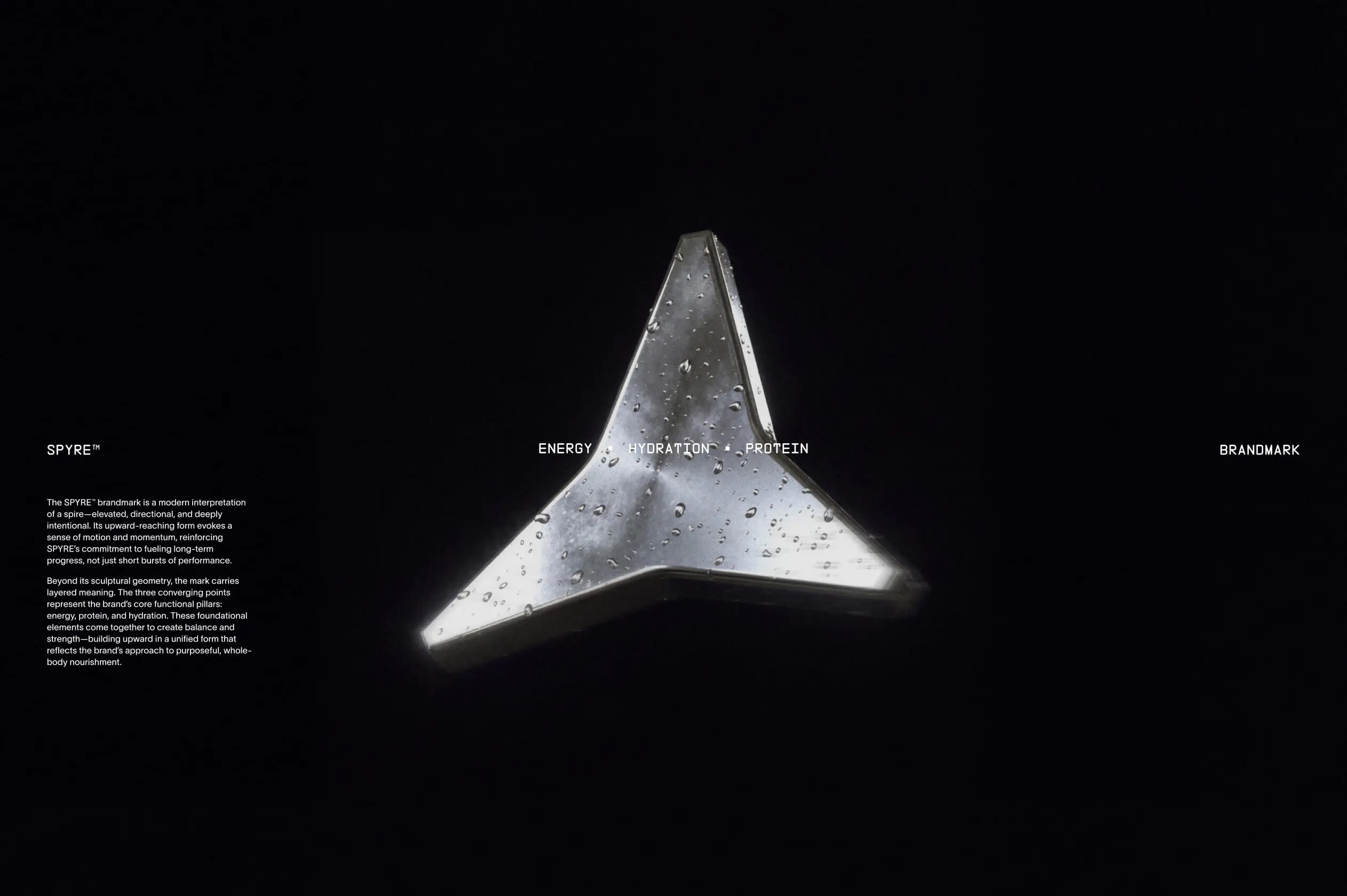 SPYRE™ brandmark presentation slide on black background featuring a polished aluminium spire sculpture with water droplets, flanked by "ENERGY · HYDRATION · PROTEIN" and brand description copy