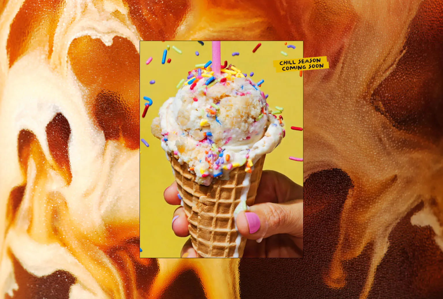 A hand holds a waffle cone loaded with sprinkle-covered ice cream against a yellow background. The photo is set inside a white border floating over a swirling brown and orange liquid background. A yellow label in the upper right reads "Chill Season Coming Soon."