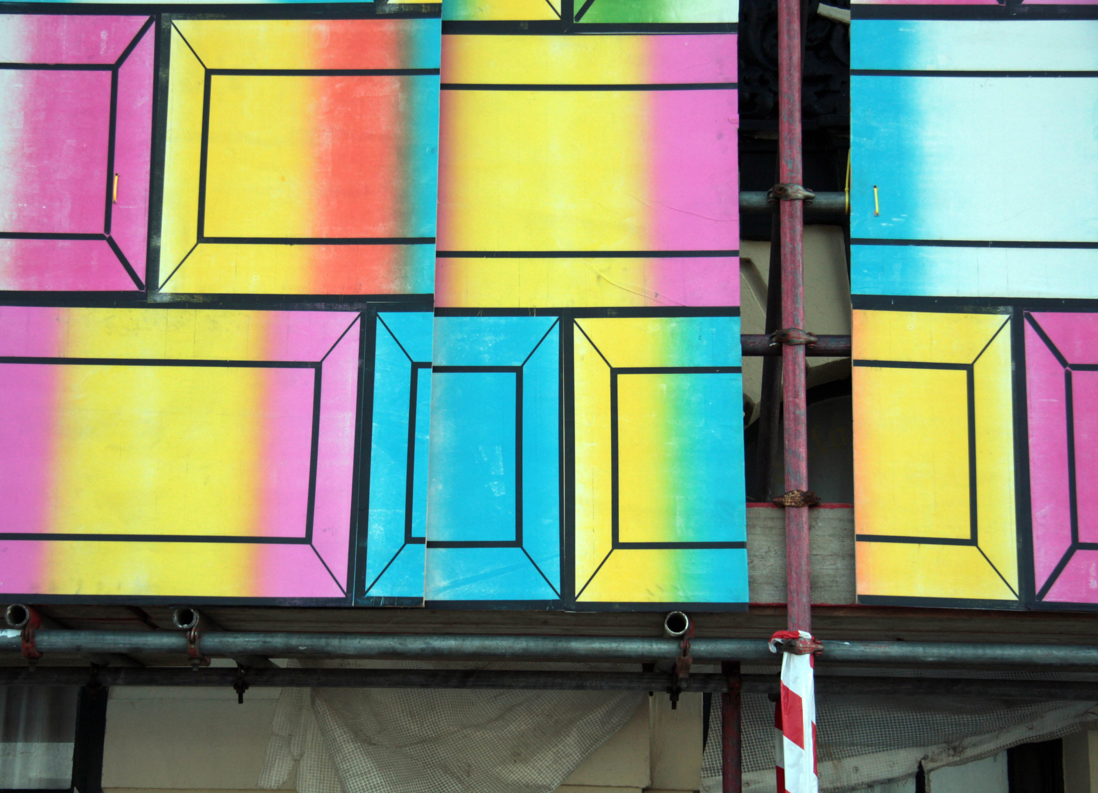 Detail of Architectural installation by Henry Coleman as part of World in a Box organized by Pete Fillingham in Margate e Kent, close up of hording of brightly colored posters mounted on scaffolding 
