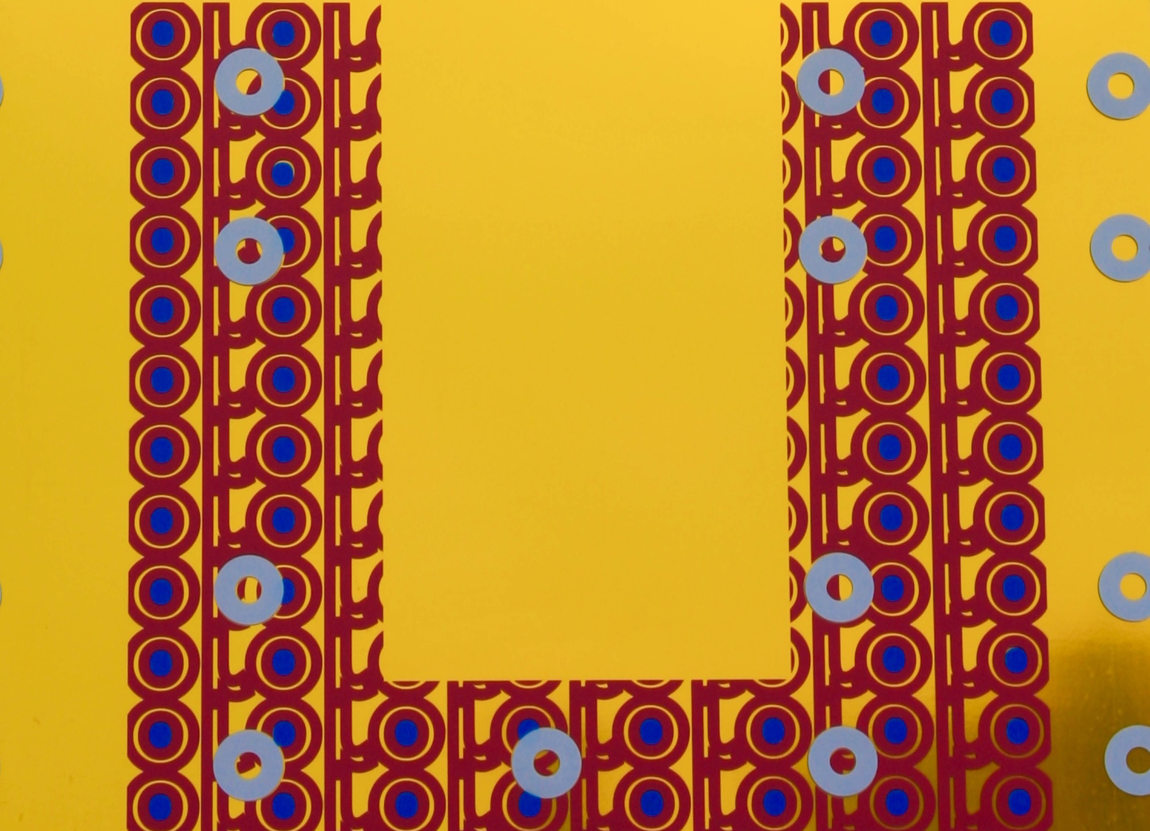'Close up  of 'oroverde' Mirror Sculpture by artist Henry Coleman with repeated and interlocking patterned of cut vinyl against a bright yellow background tone