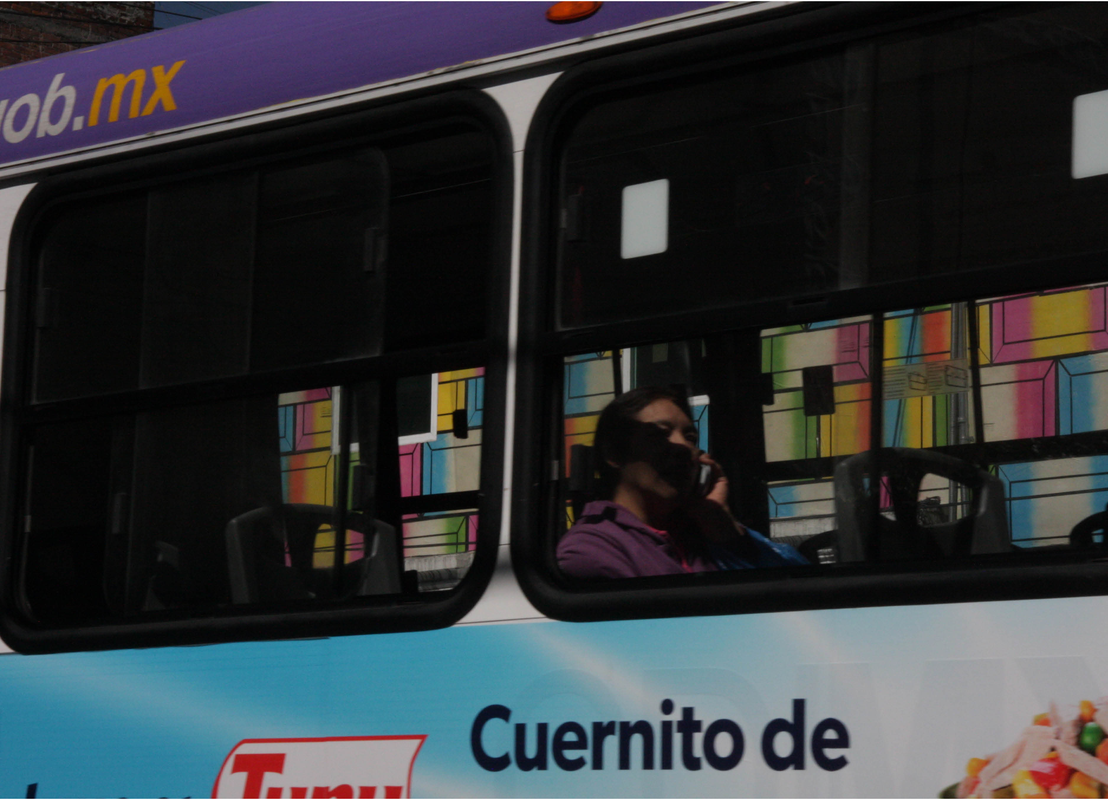 'Telon' architectural poster installation of Banderas posters by UK artist Henry Coleman seen through the window of a Mexico city bus
