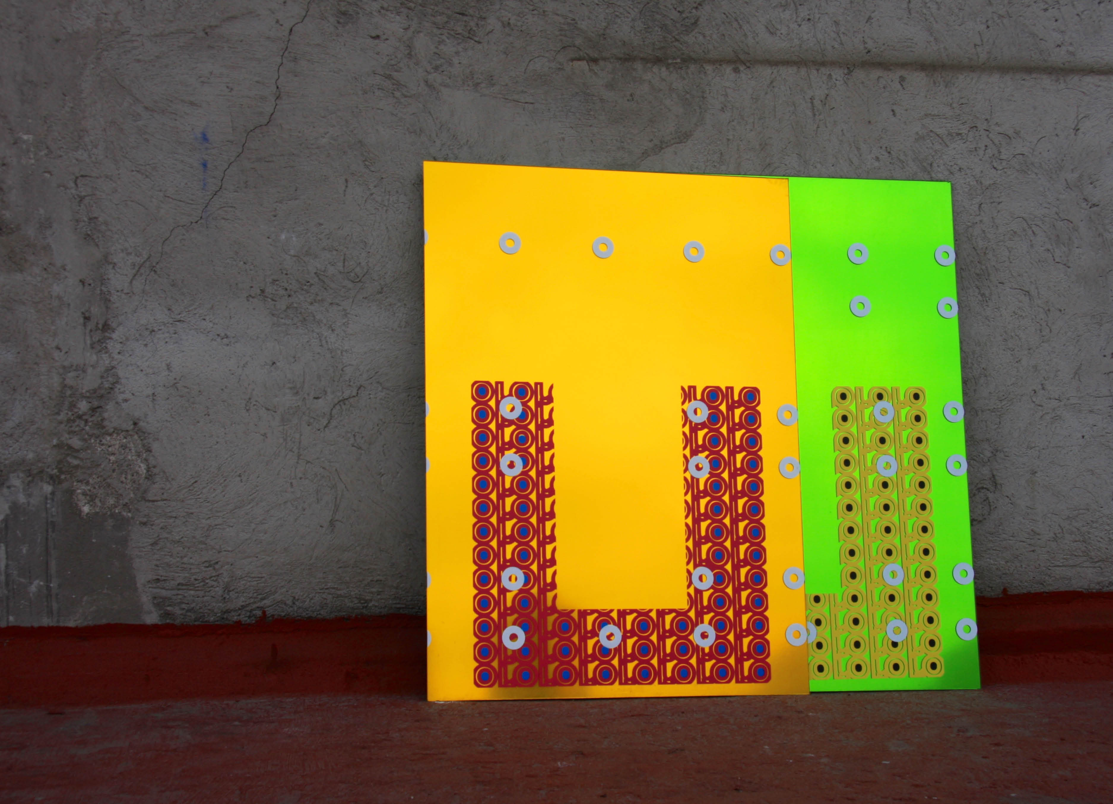 ' 'oroverde' Mirror Sculpture by artist Henry Coleman with two brightly colored and pattern mirrors lent up against an external rooftop wall reflecting the evening sunlight