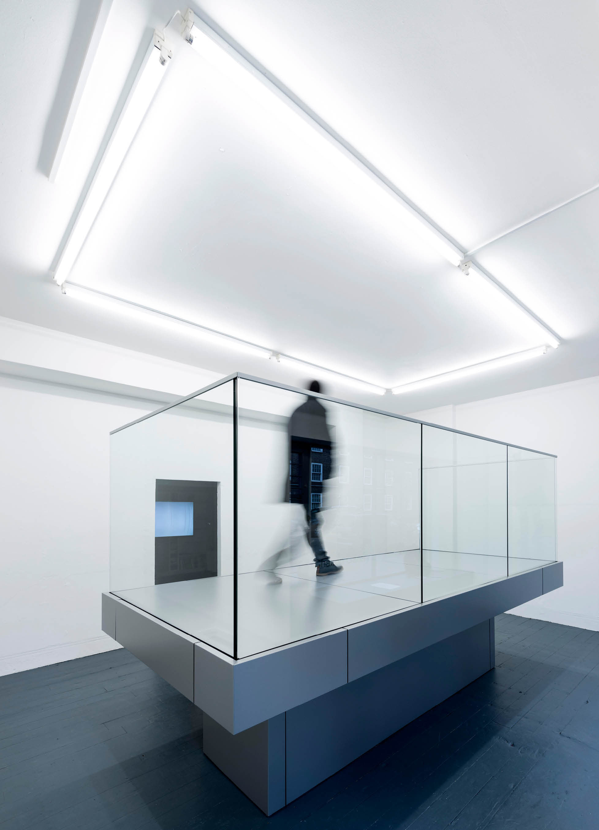 'My Sky' exhibition  by artist Henry Coleman at Chalton Street gallery, a man walks quickly around a raised balcony platform his legs are blurred