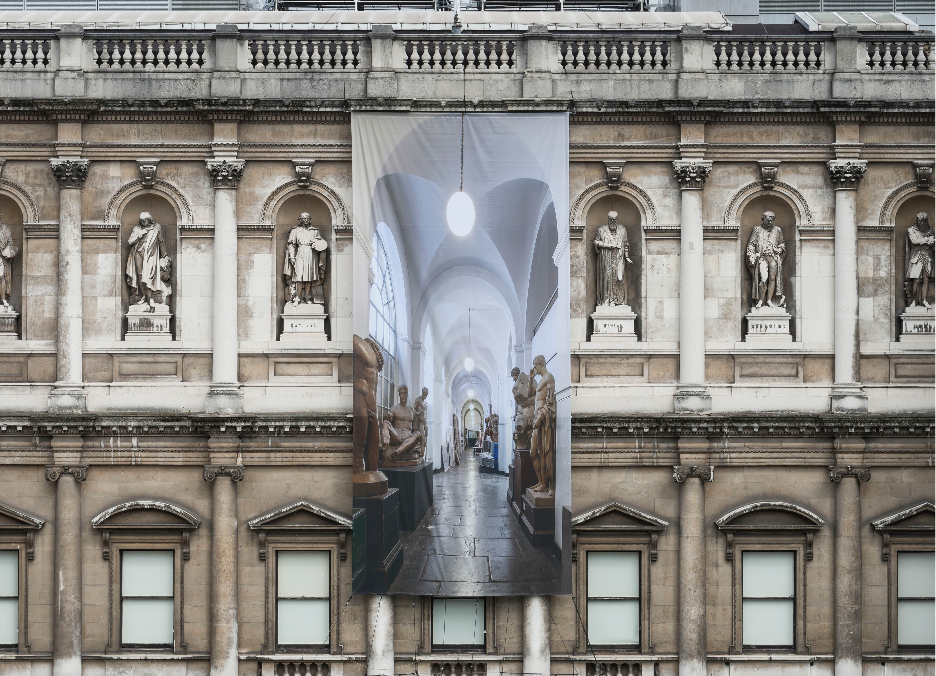 'The Greater Order', Sculptural installation by artist Henry Coleman across the Royal Academy buildings, London. Close up of  large banner with  image of the  Cast corridor of the Royal Academy schools on the facade of Burlington House 
