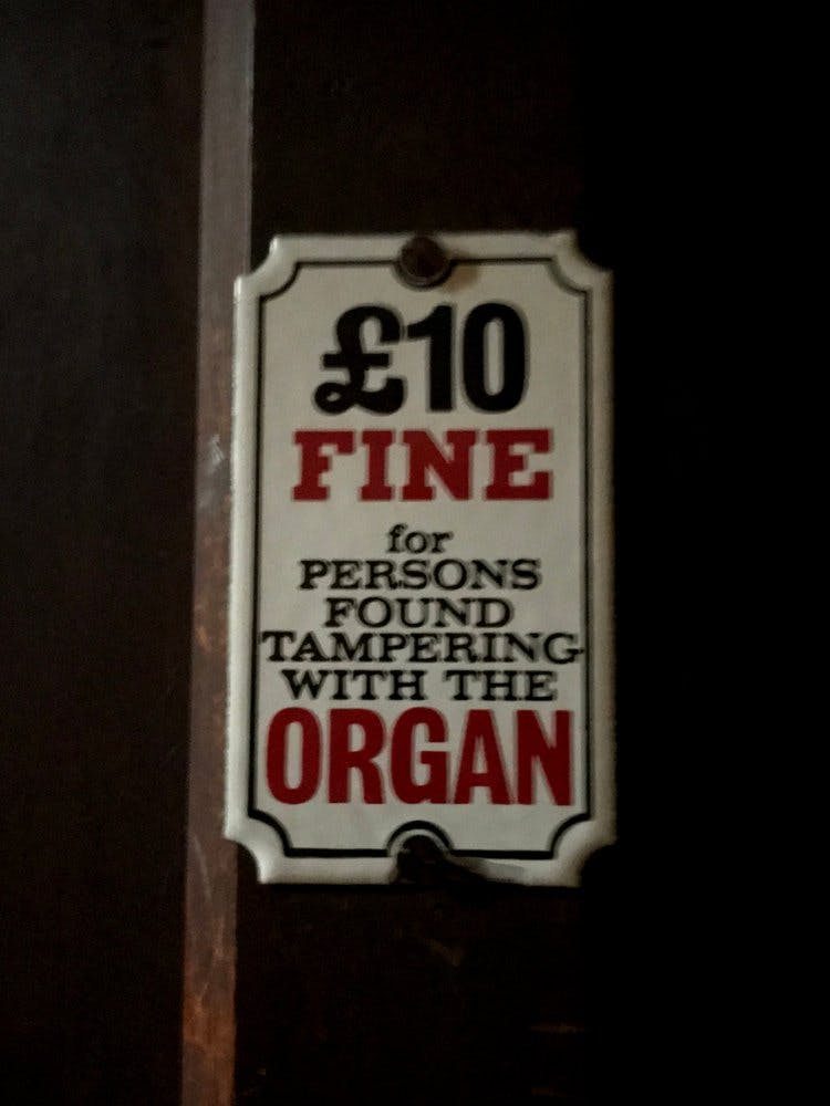 A sign reading "£10 fine for persons found tampering with the organ"