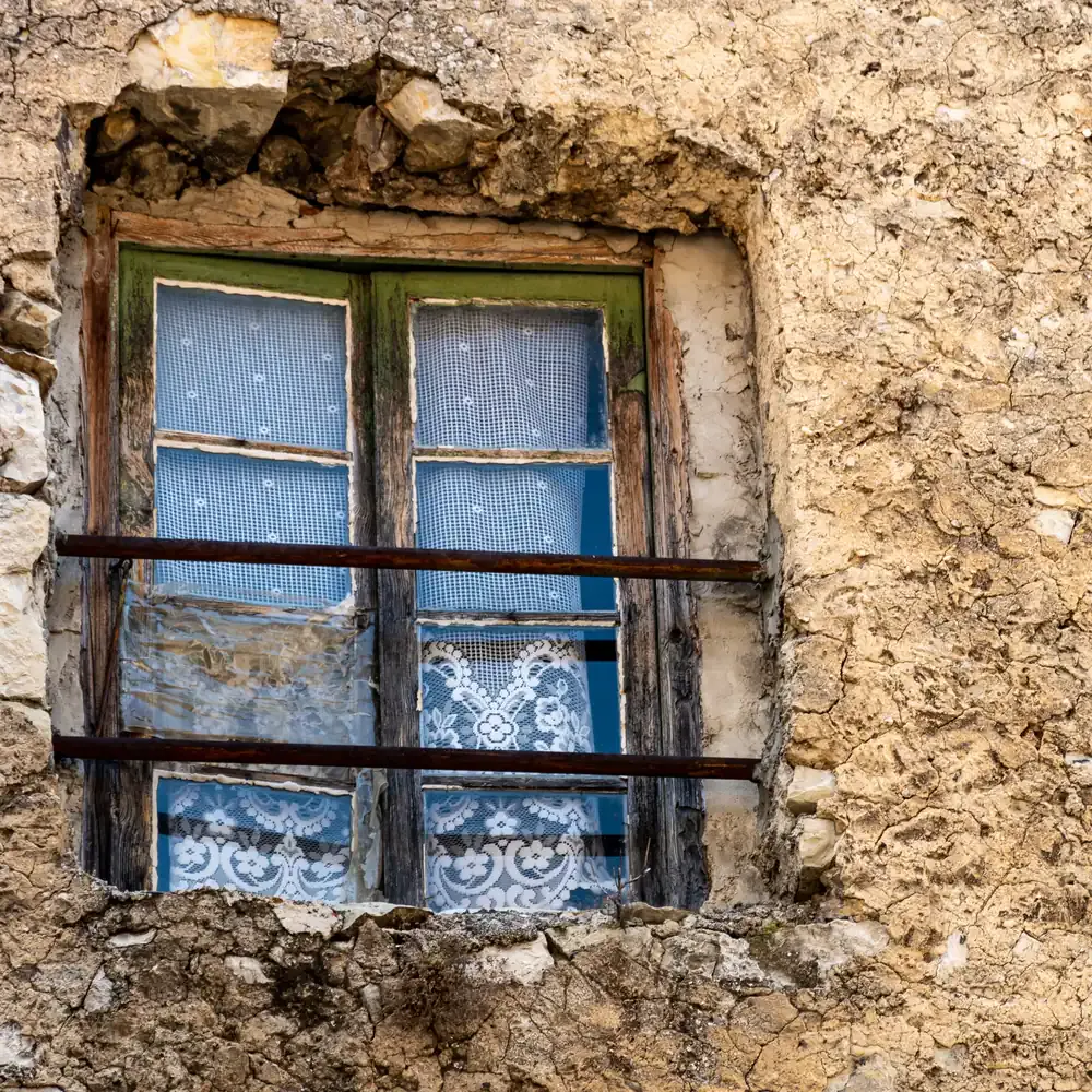 Vieille fenêtre en bois dans un mur en pierre