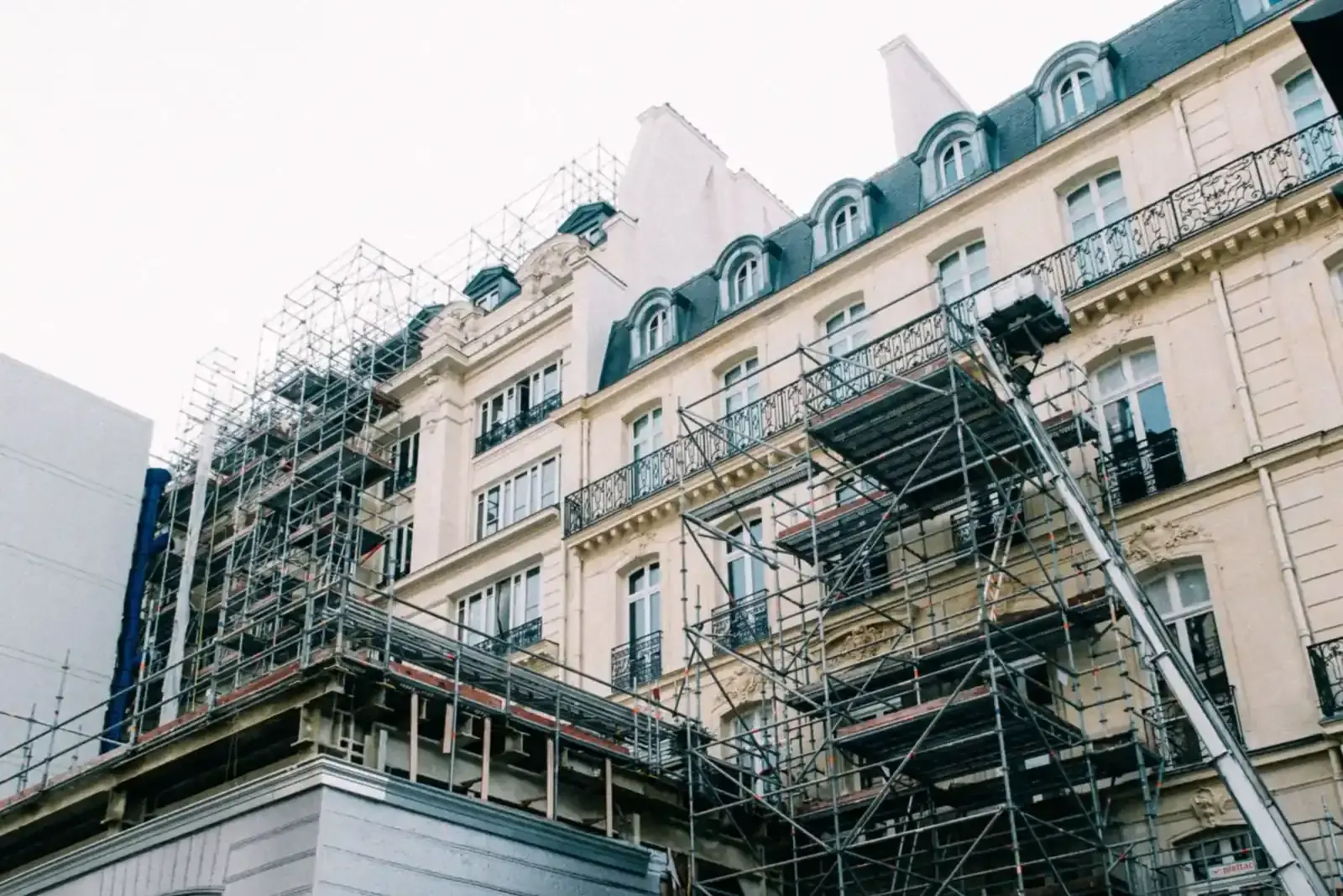 Immeuble ancien de style haussmannien sous échafaudages pendant sa rénovation, dans une rue parisienne
