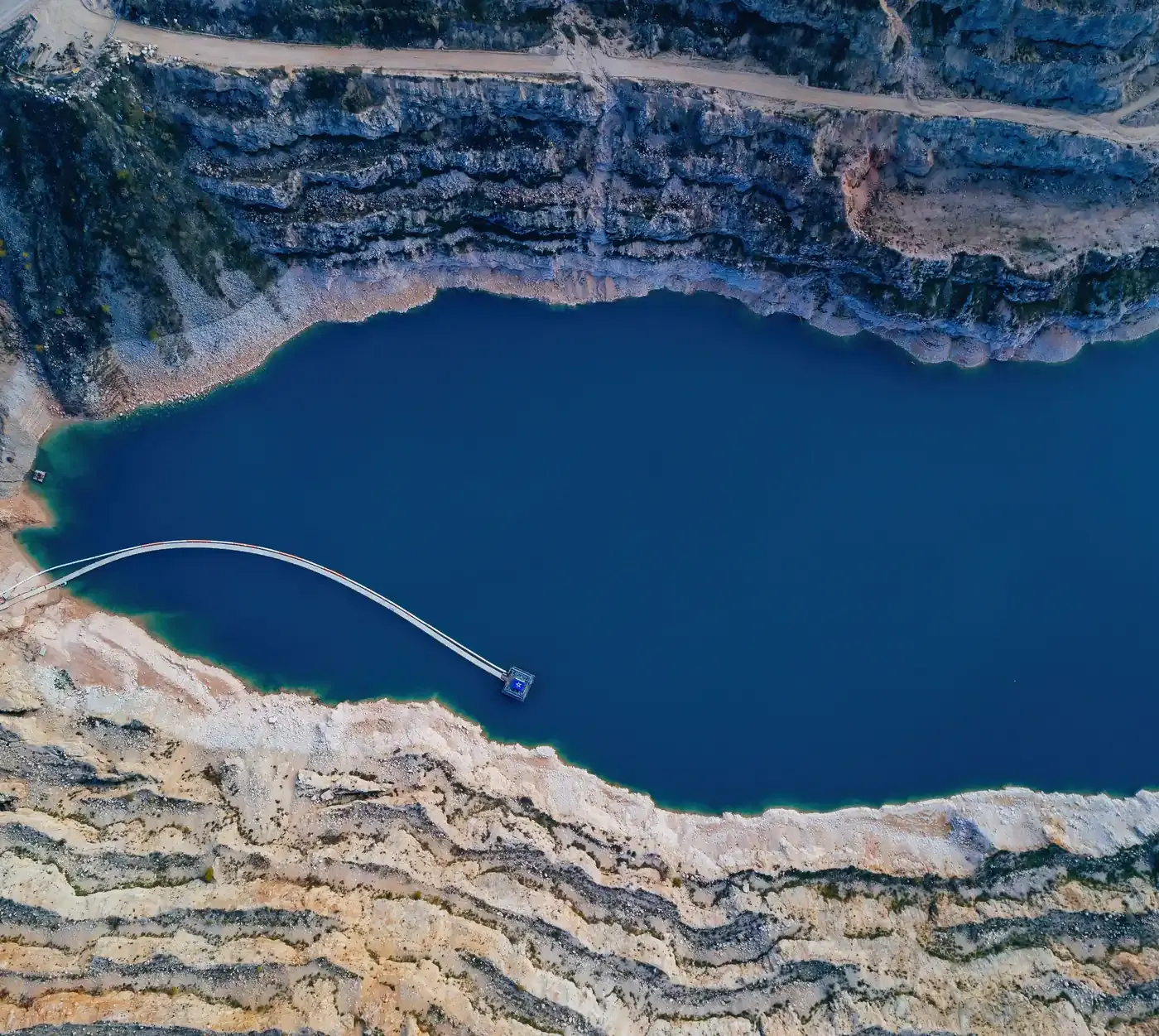 Vue aérienne d'un lac bleu profond entouré de parois rocheuses