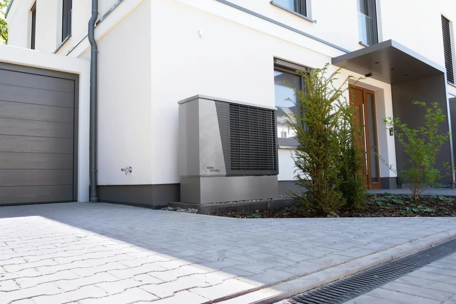 Unité extérieure de pompe à chaleur air/eau posée contre la façade d'une maison
