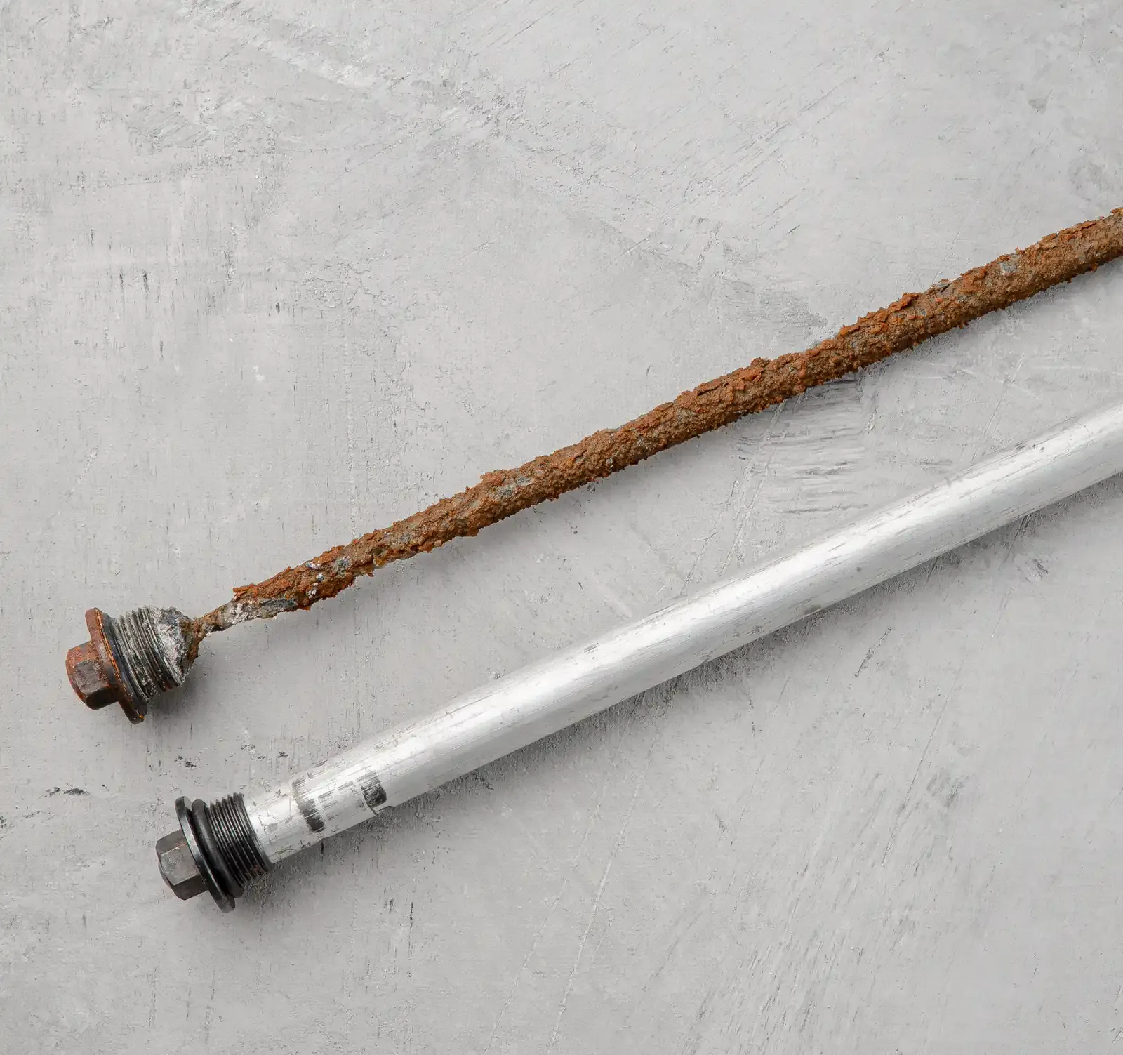 Anode de chauffe-eau usée et corrodée à côté d'une anode neuve