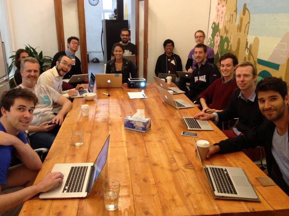 Canva Team, Sitting, Wooden table, Laptops