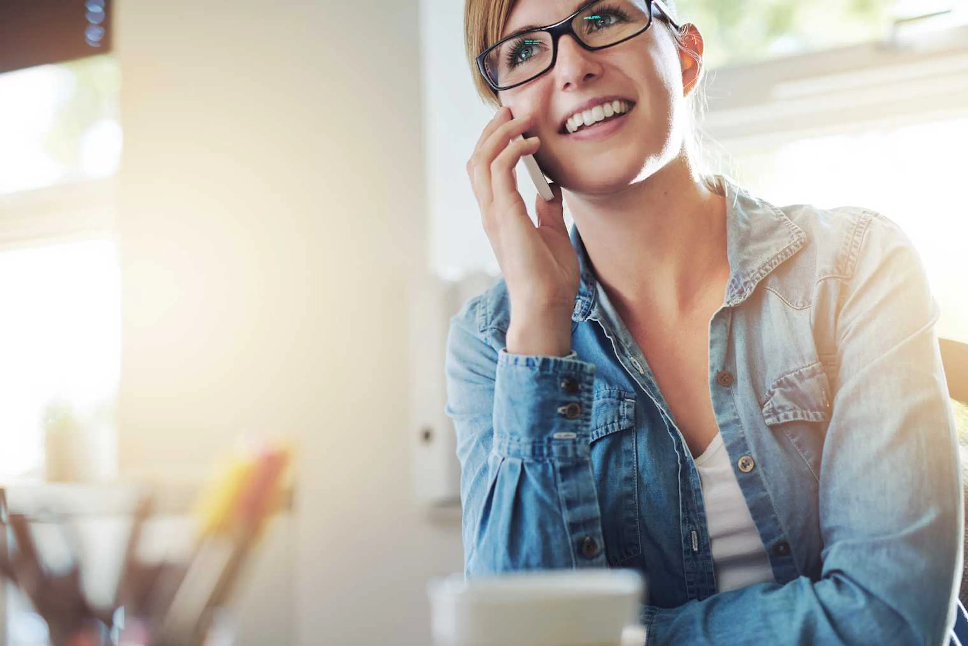 Young woman smiling wearing glasses while on the phone