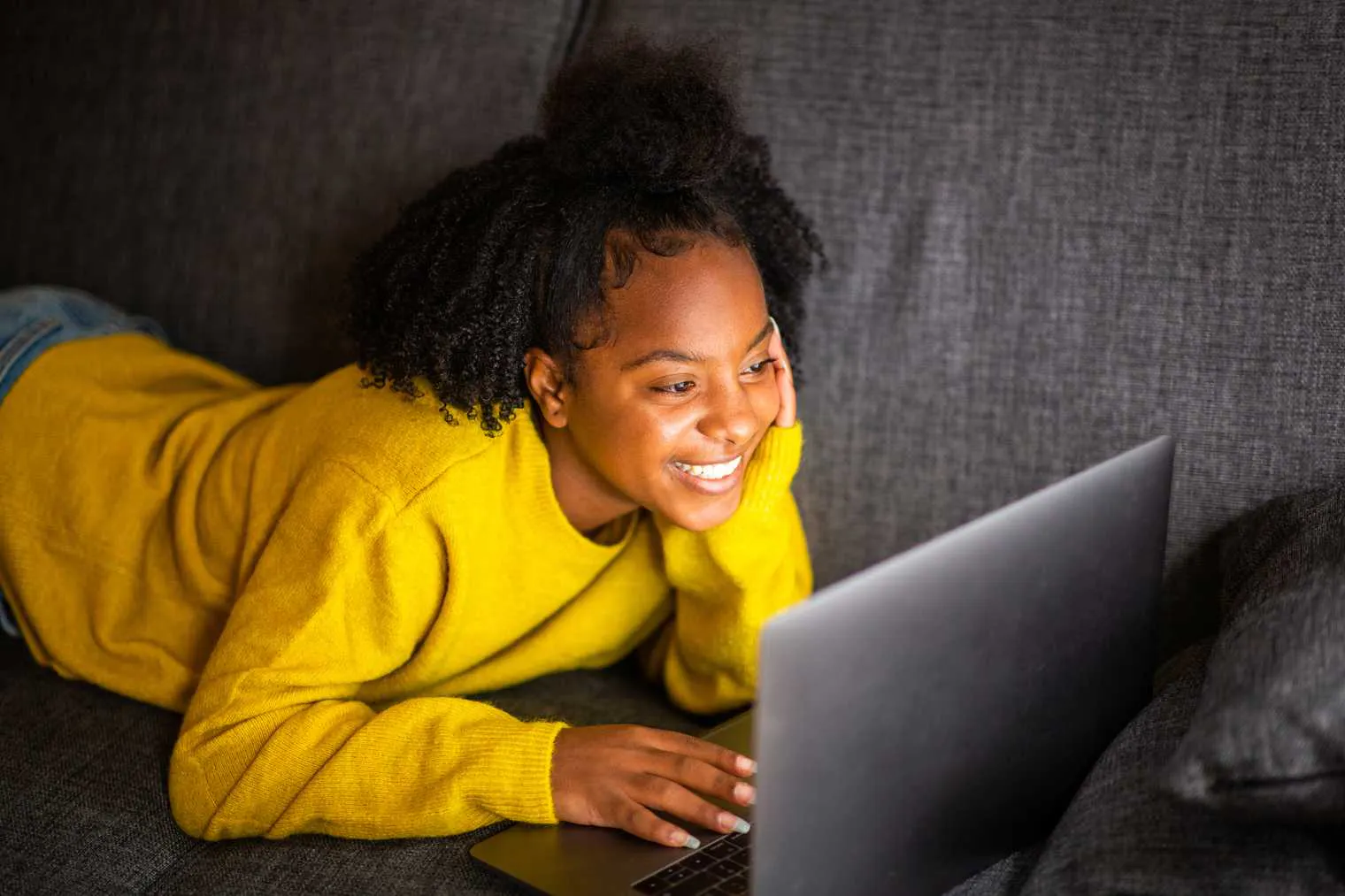 Young girl smiling at laptop