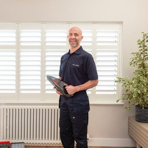 hillarys advisor standing in front of window with shutters