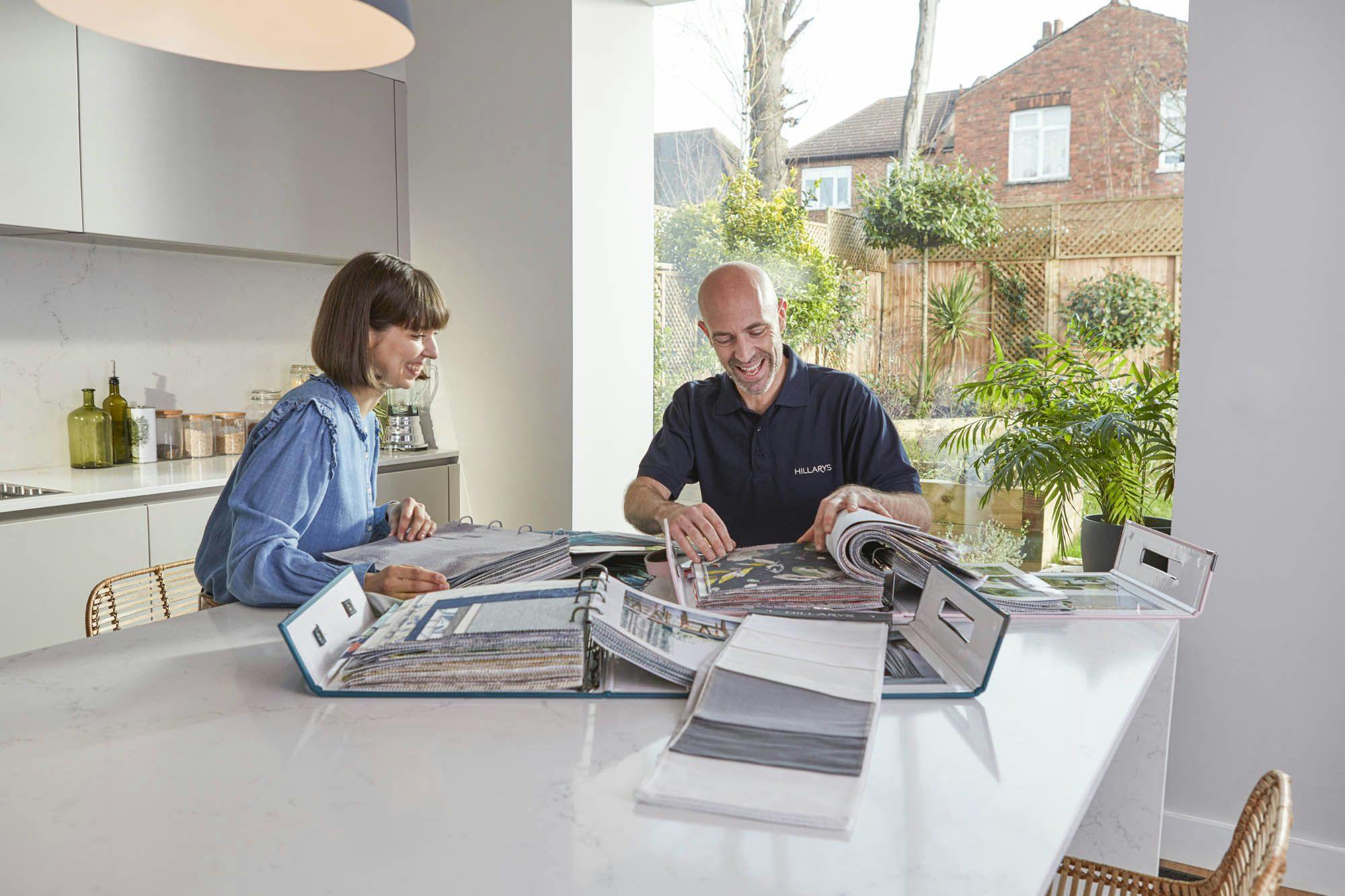 Advisor showing woman samples of swatches at her kitchen table