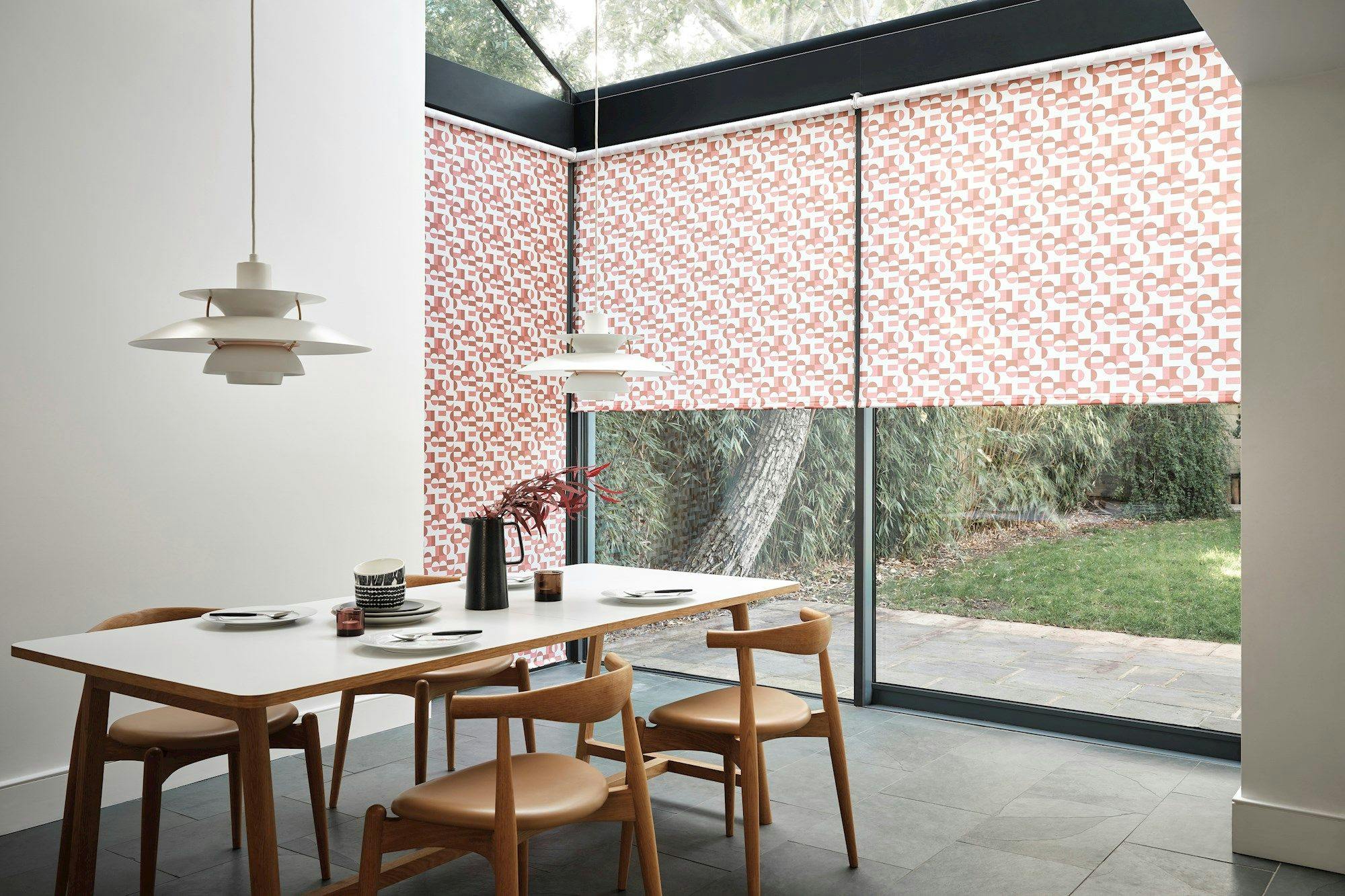 Ingrid Pumpkin Roller blind displayed on glass windows in a dining room 