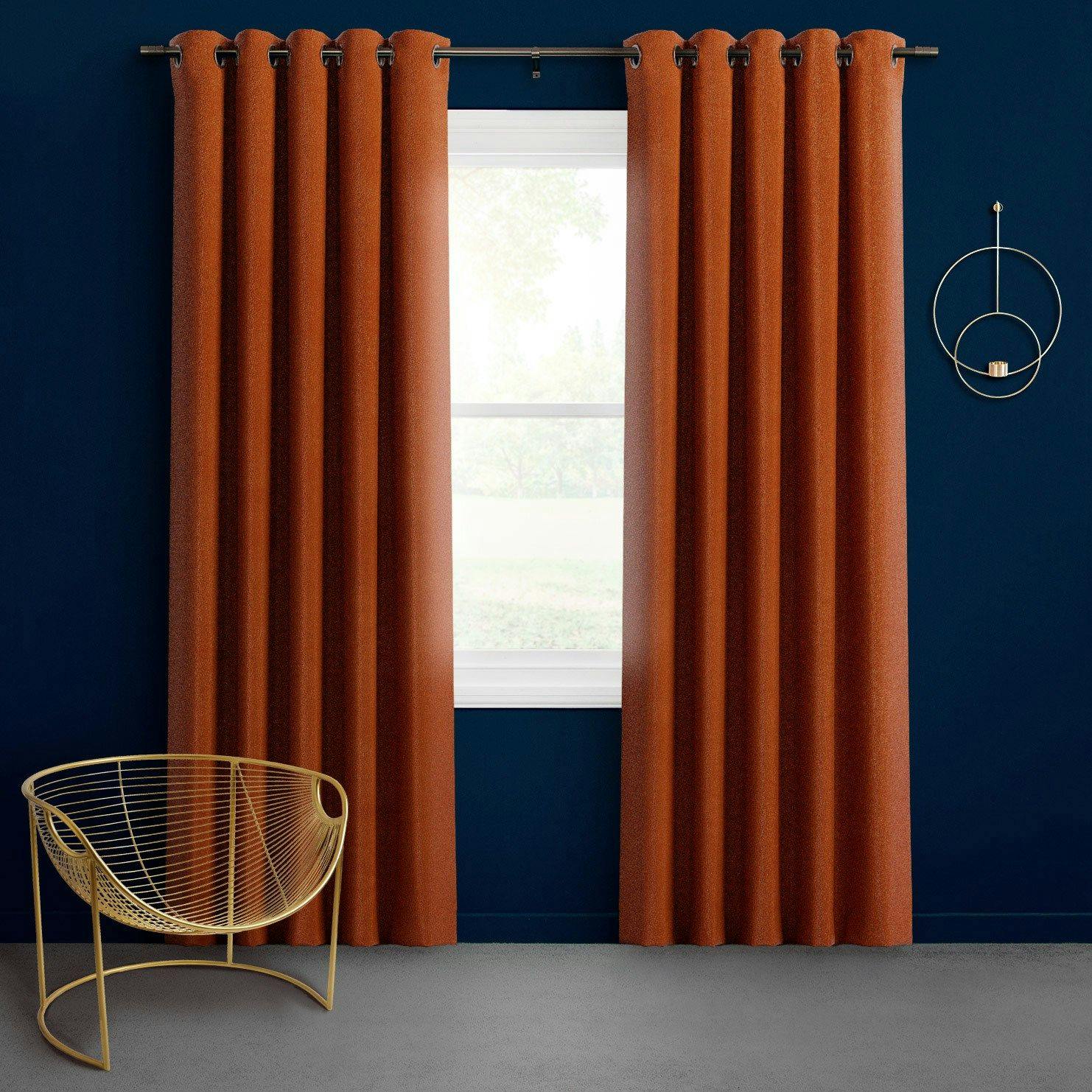 Orange velvet curtains in a cosy living room with yellow accents