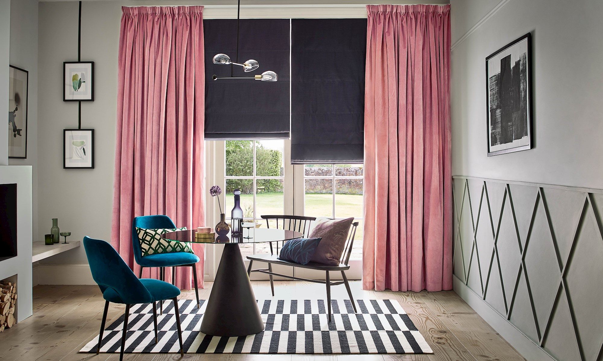 Velvet, rose pink curtains over a dark roman blind in a modern living room