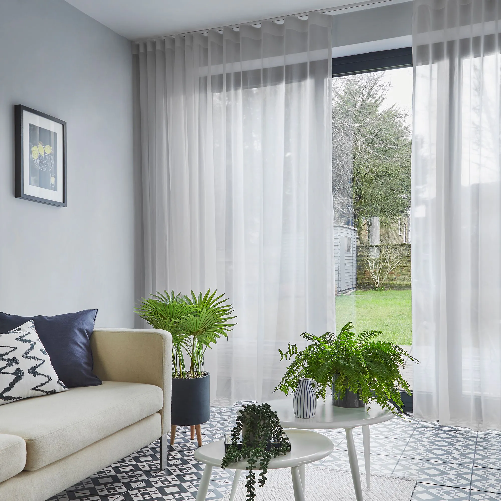 Clarity silver voile curtain displayed on an external window next to a wardrobe, slightly opened allowing light into the bedroom.