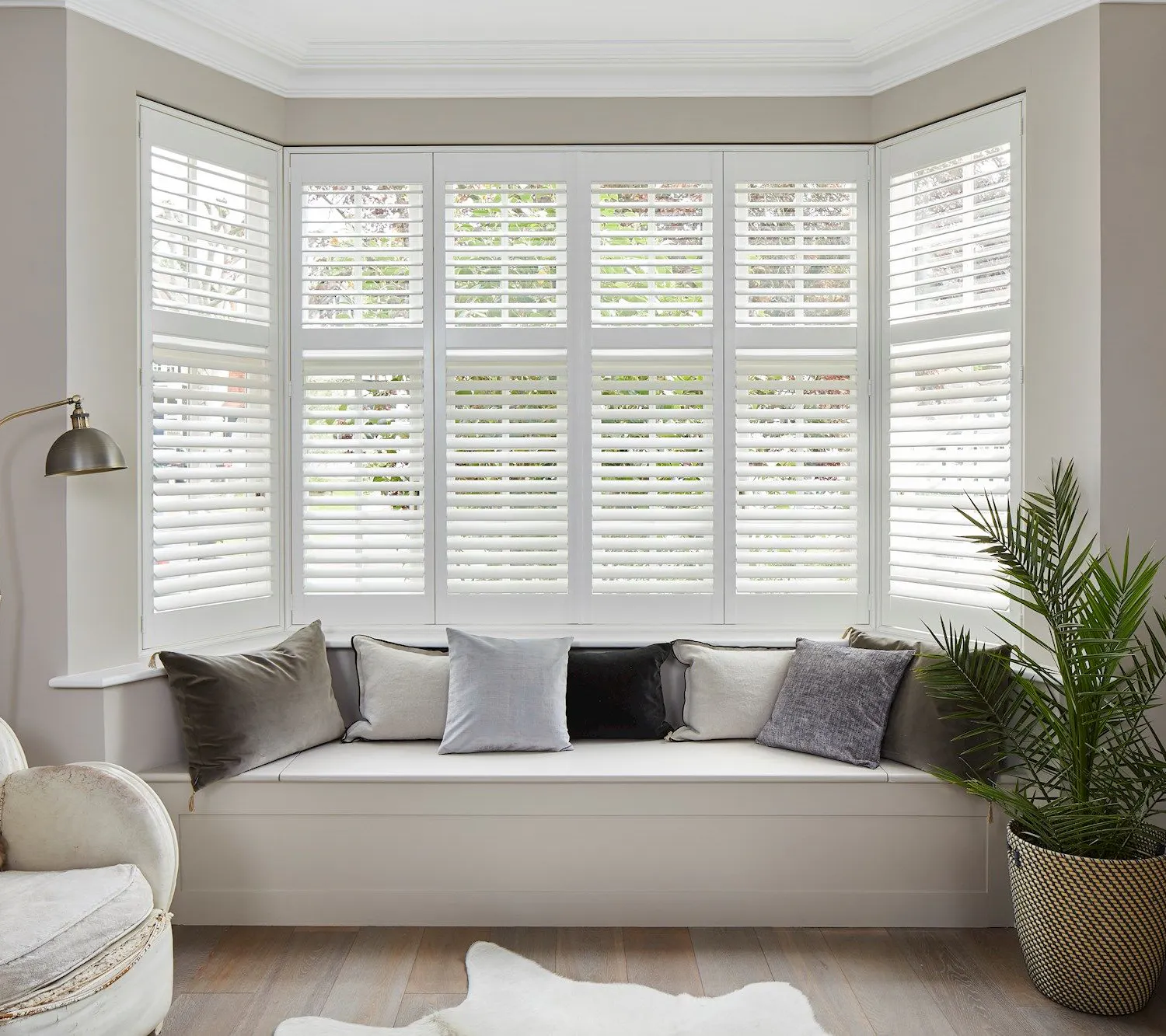 Richmond Silkwhite Shutters in a lounge window with white furniture