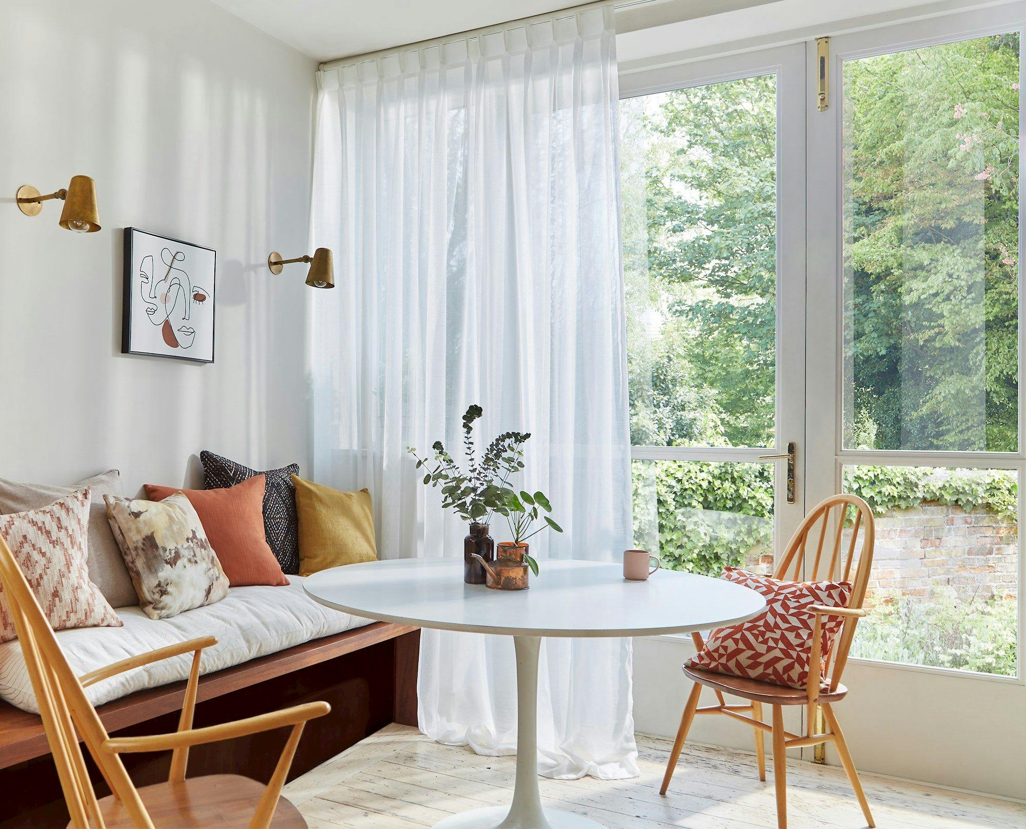 white voile curtains in front of french doors in room with sofa, table and chairs