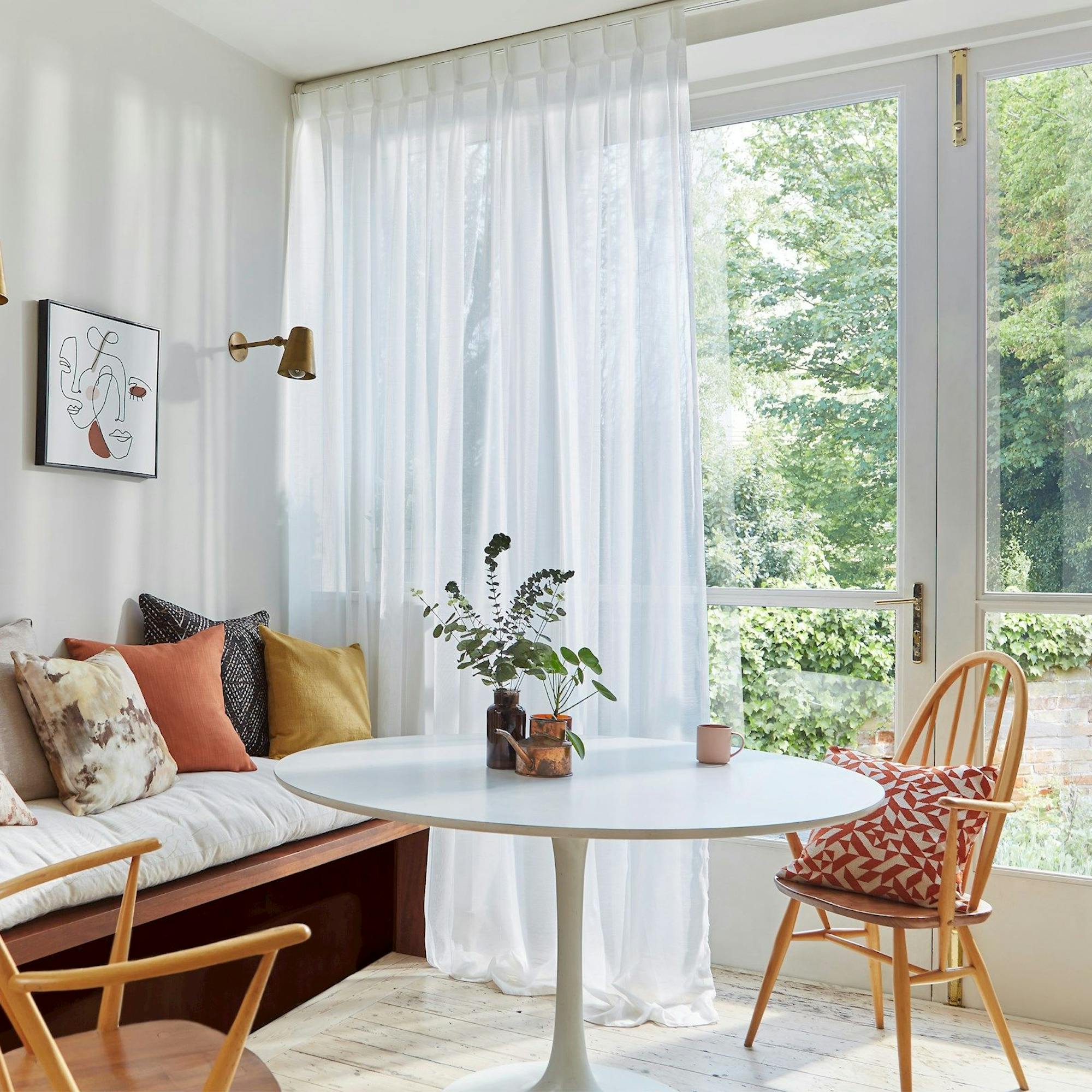 white voile curtains in front of french doors in room with sofa, table and chairs