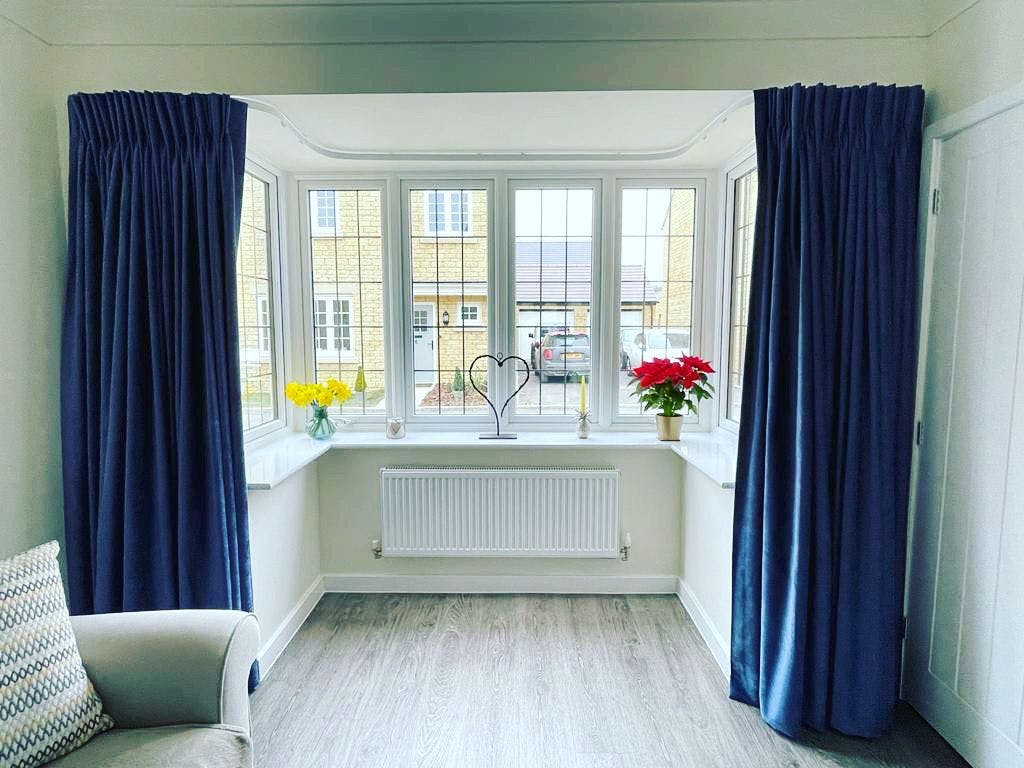 Deep Blue bay window curtains in a bright living room 