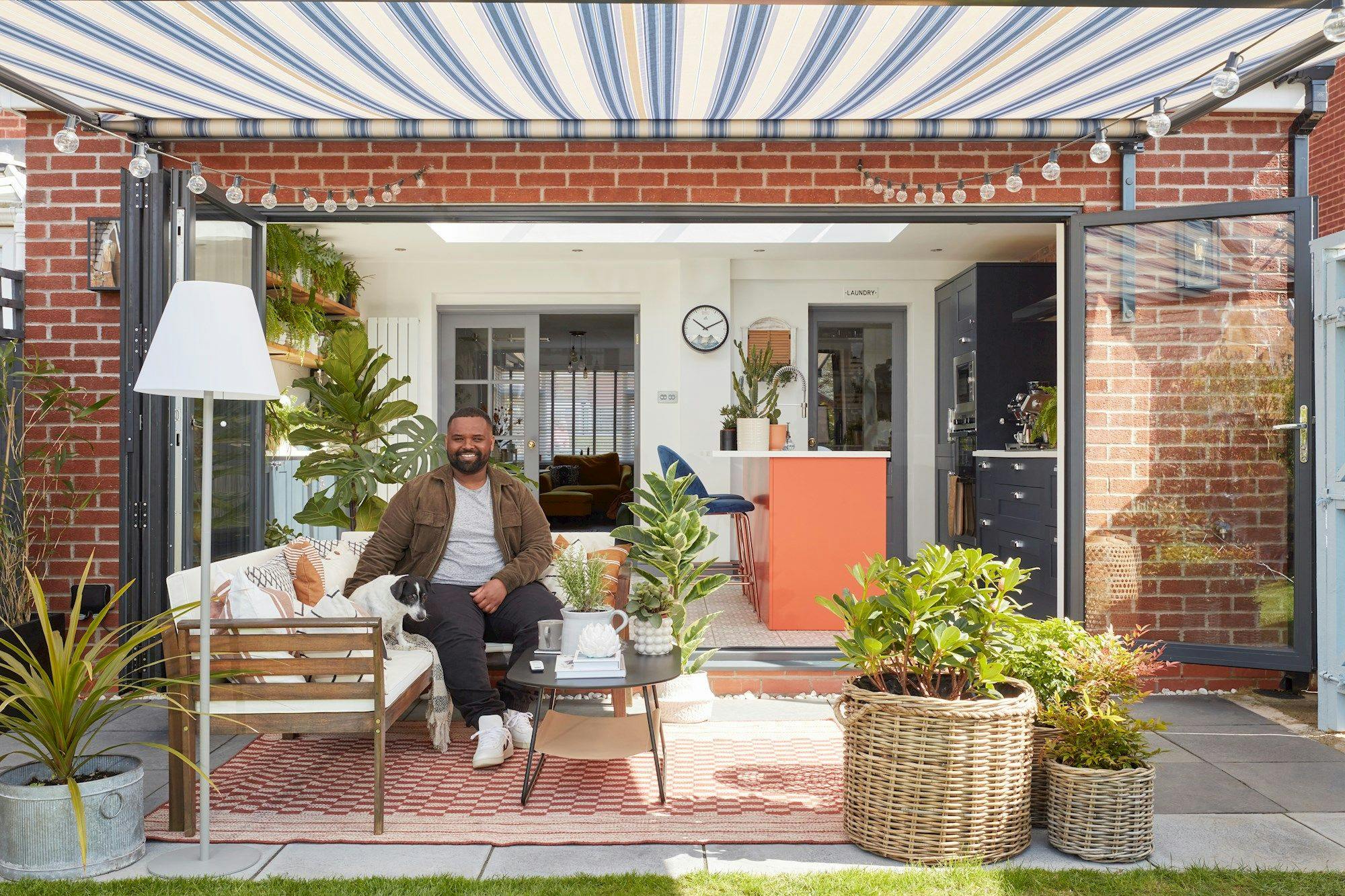 Mo sat on a bench under an awning in his garden 