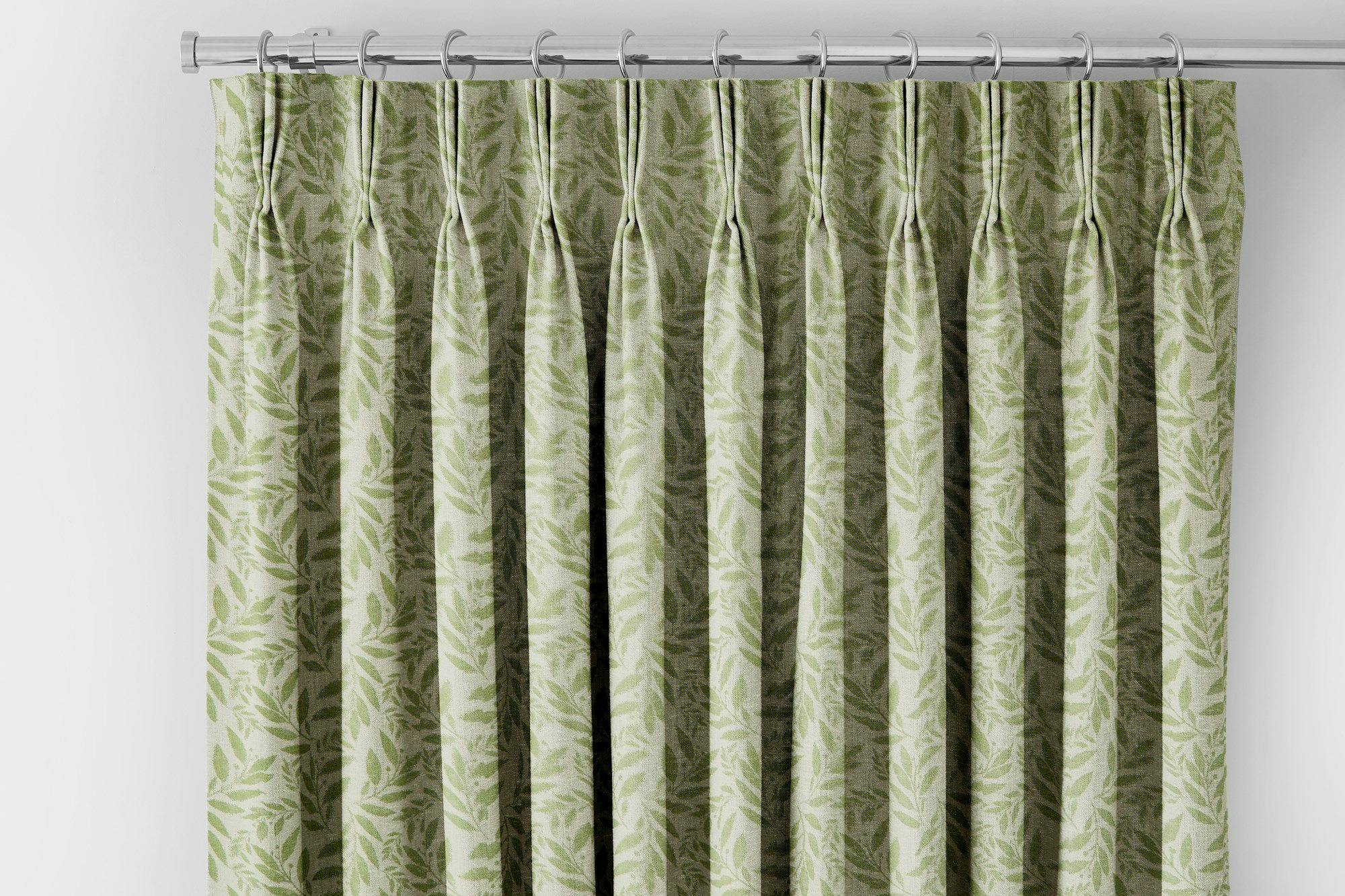 light green curtain with darker green leaf pattern header on a silver curtain pole