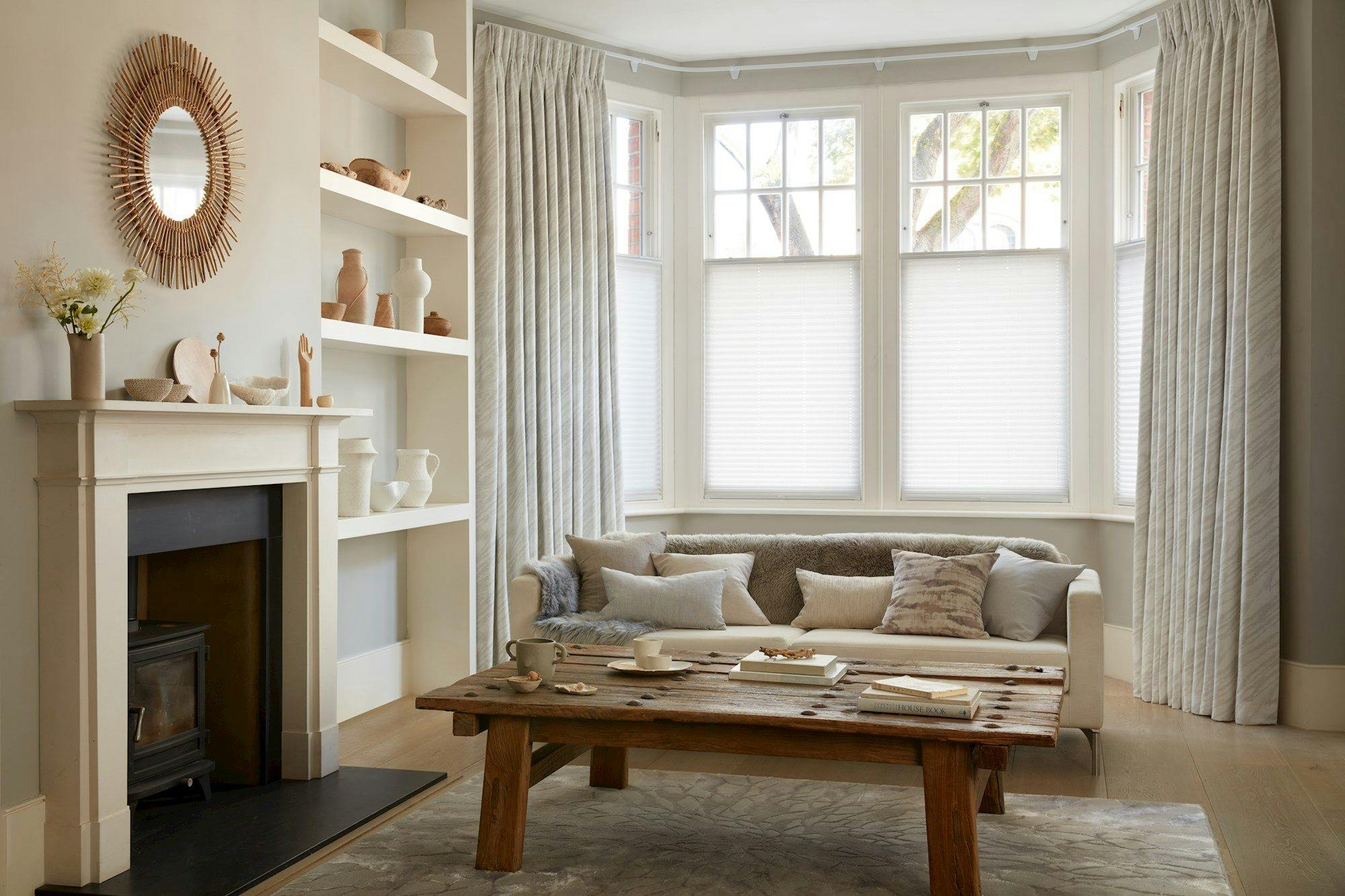 Camo white pleated blinds paired with drift alabaster curtains in cosy living room