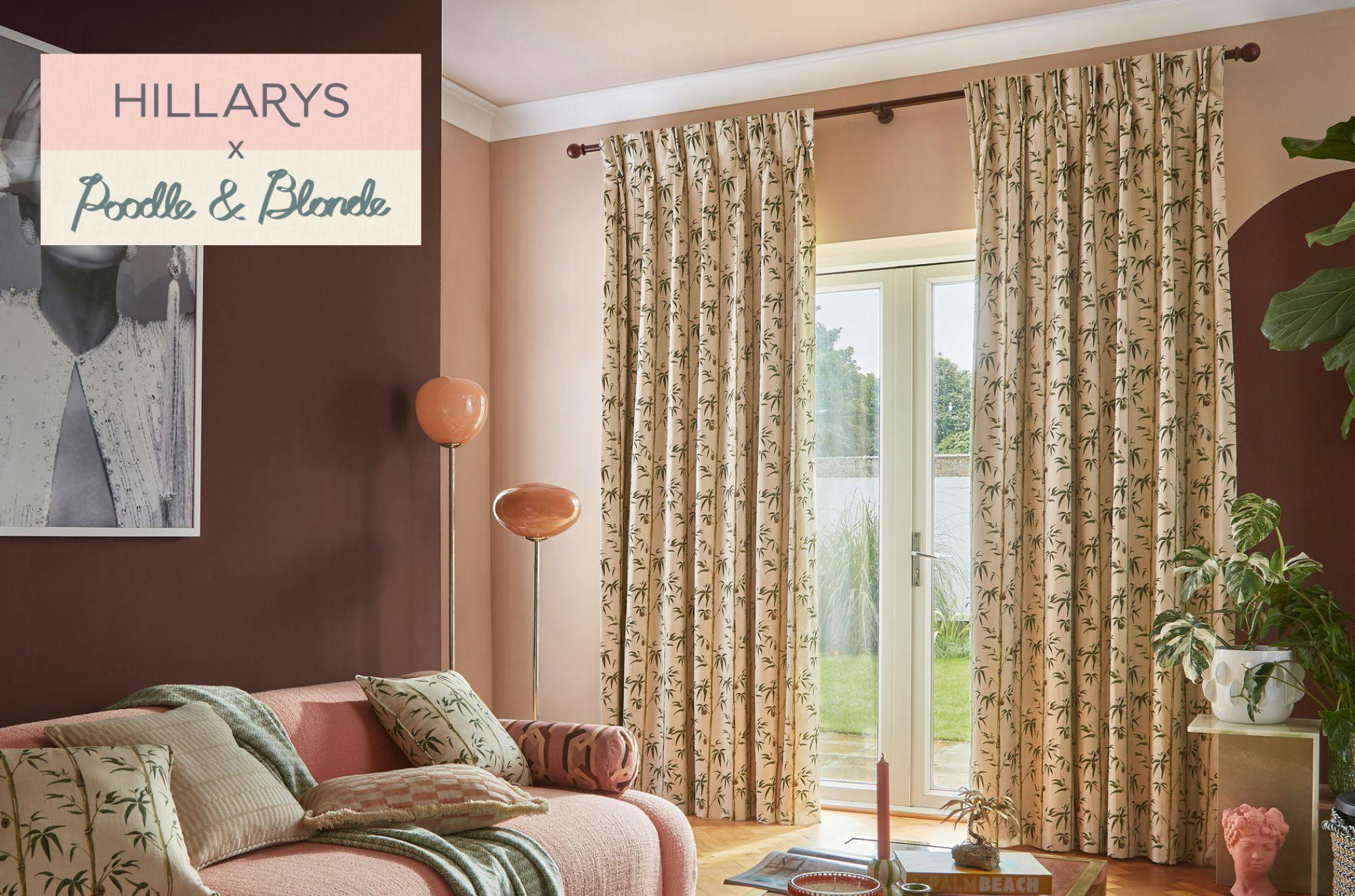 Curtains with leaf patterns hang by glass doors in a cozy living room with pink walls and upholstery. Text reads "HILLARYS x Poodle & Blonde." A standing lamp and plants enhance the decor.