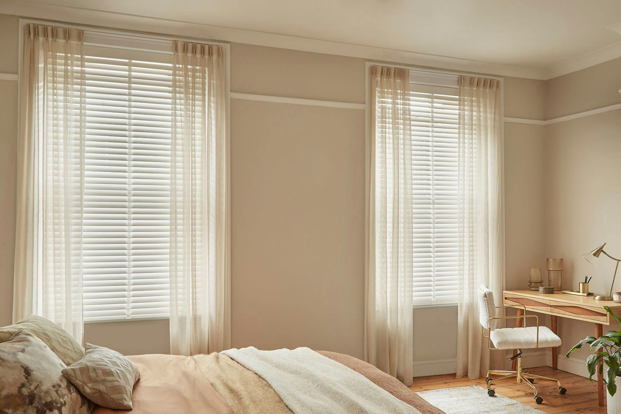 White and cream bedroom with white wooden blinds and voile curtains