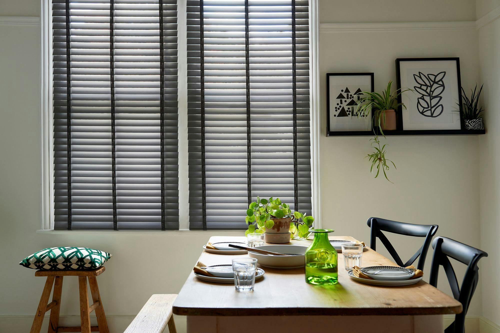 Black wooden blinds shading a dining room