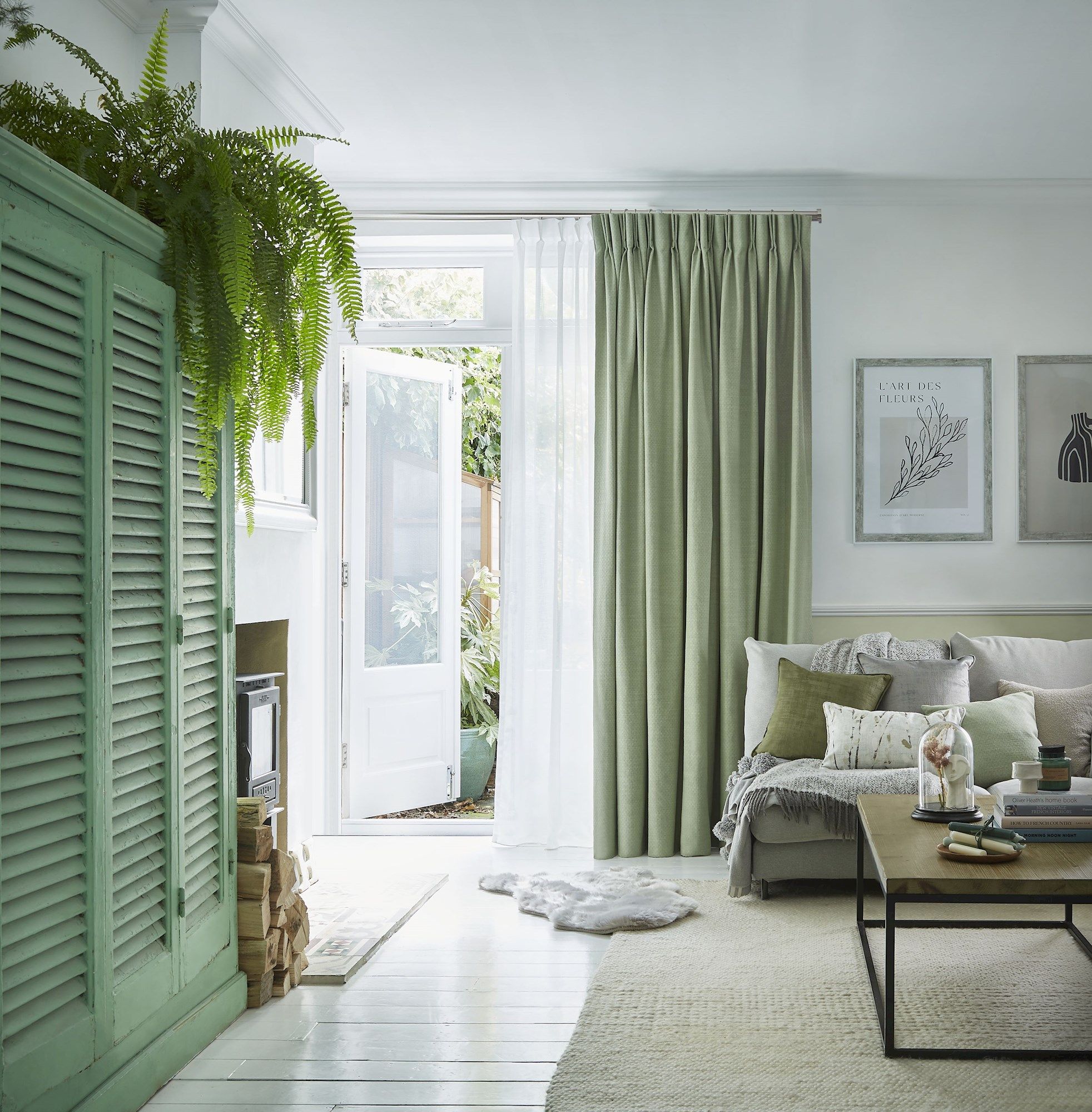 Pearl olive green floor length pinch pleat curtains paired with voiles in cosy living room