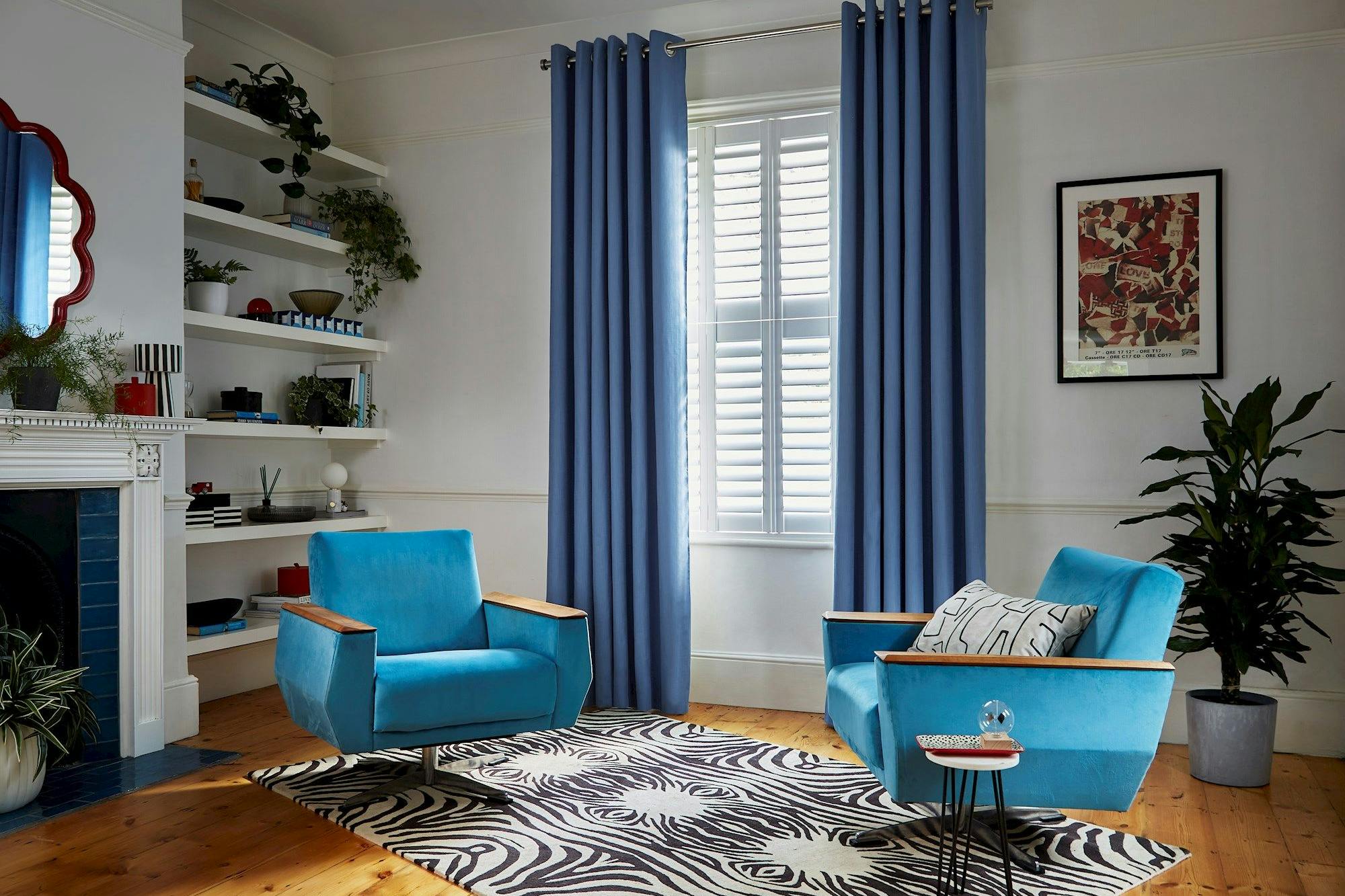 Faso cornflower blue eyelet curtains paired with white shutters in living room