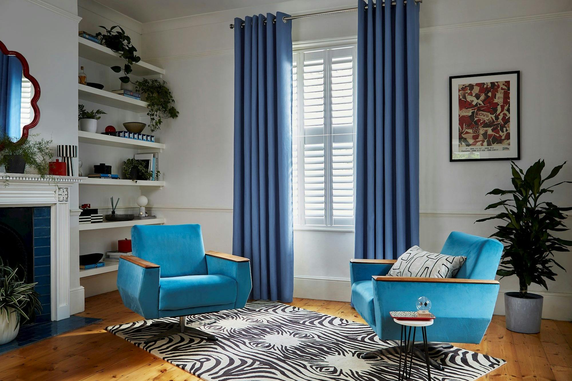 Faso cornflower blue eyelet curtains paired with white shutters in living room