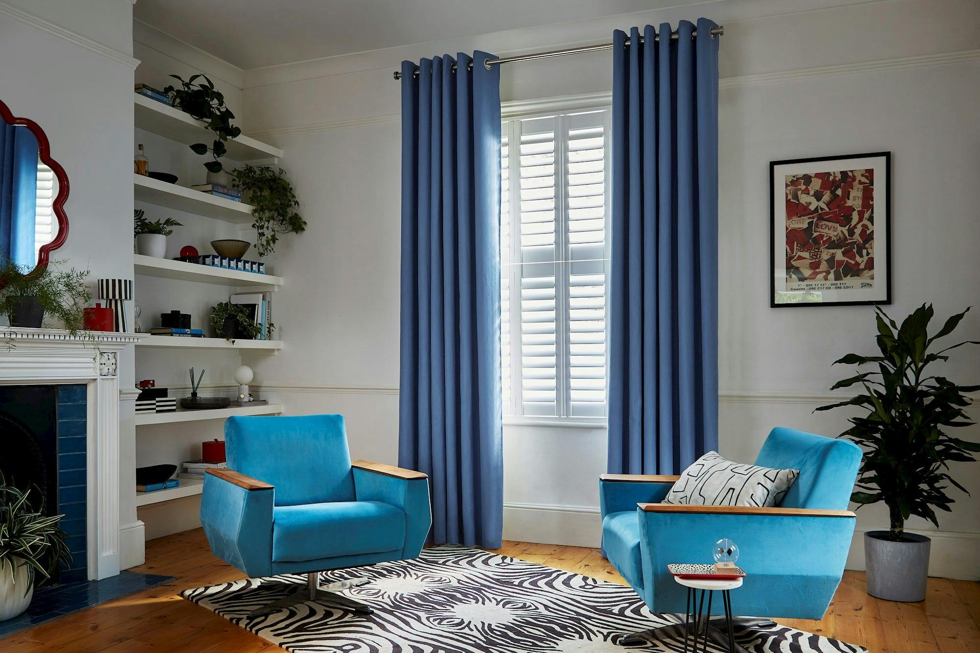 Faso cornflower blue eyelet curtains paired with white shutters in living room