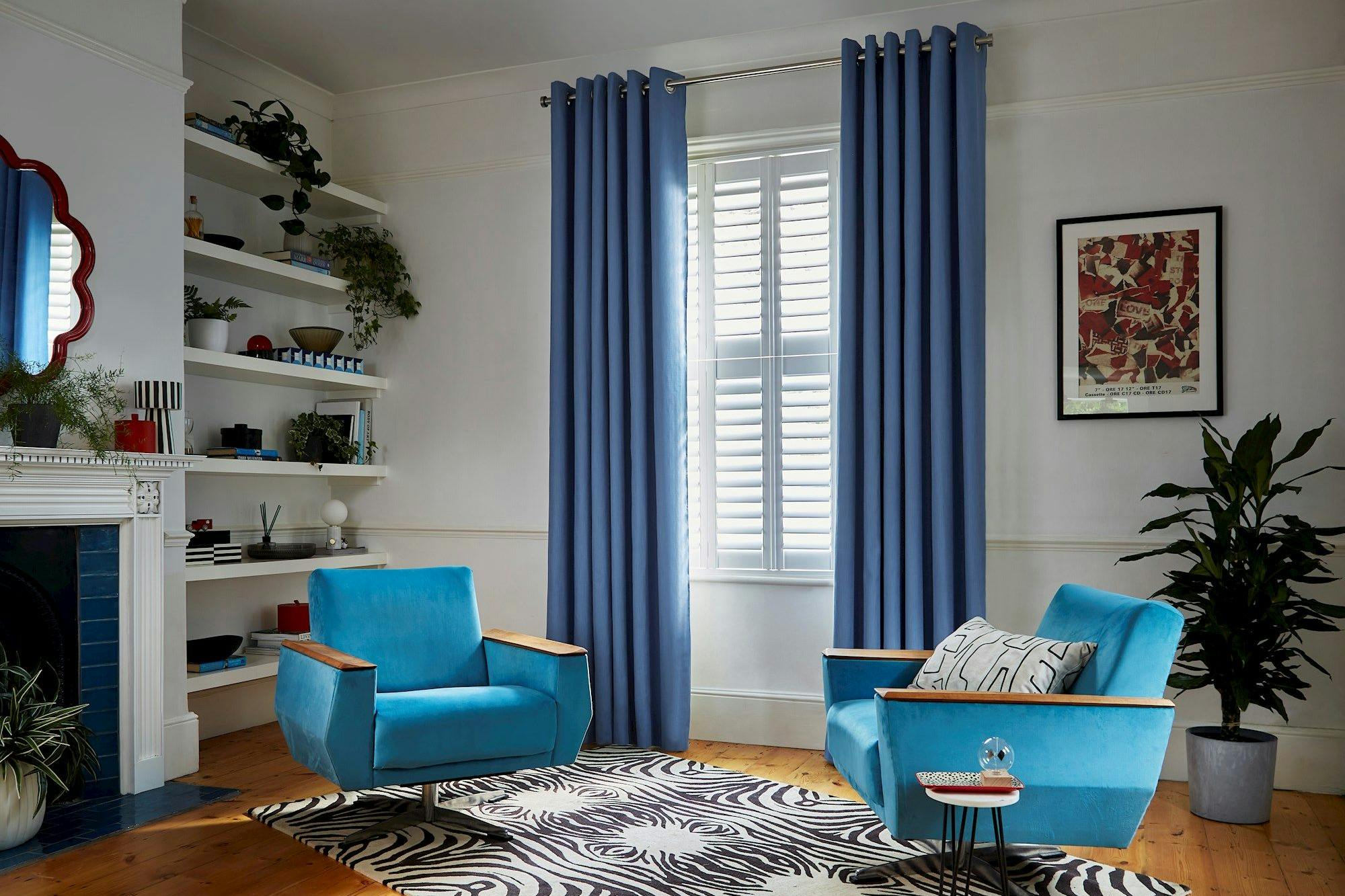 Faso cornflower blue eyelet curtains paired with white shutters in living room